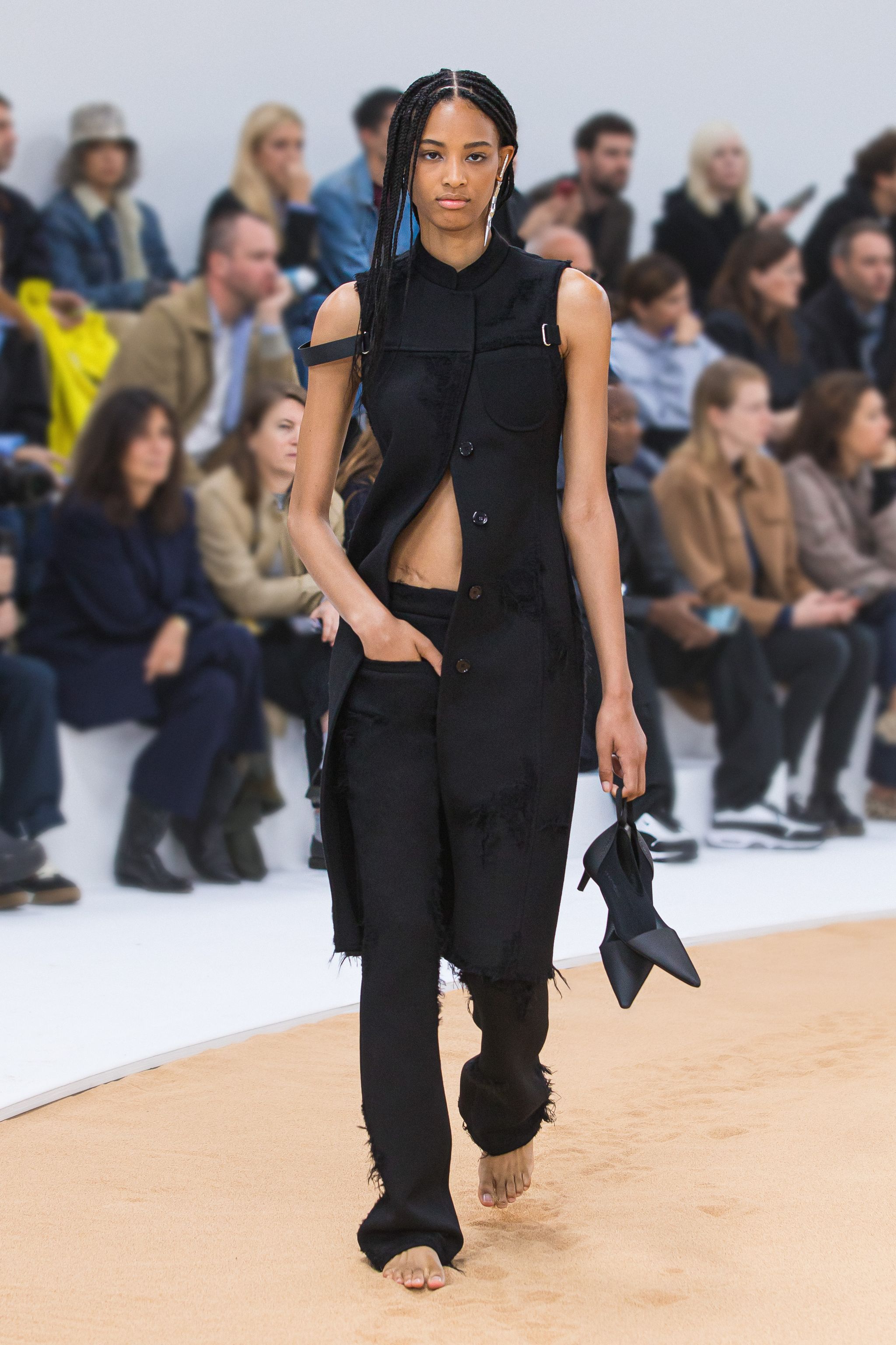 Elegant black Courrèges fashion model on runway, showcasing contemporary style for ecommerce.