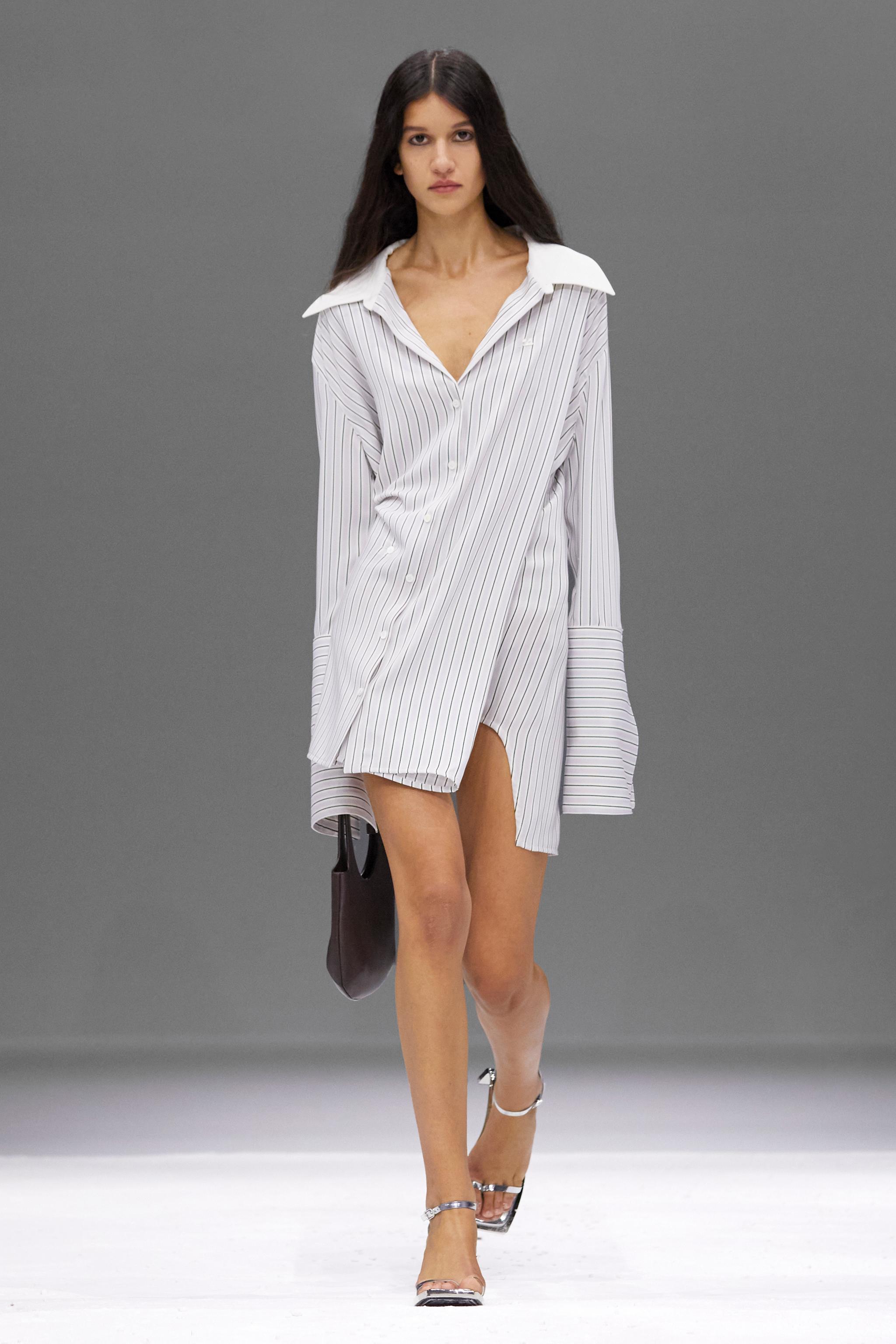 Elegant model wearing a stylish striped shirt dress by Courrèges on the runway.