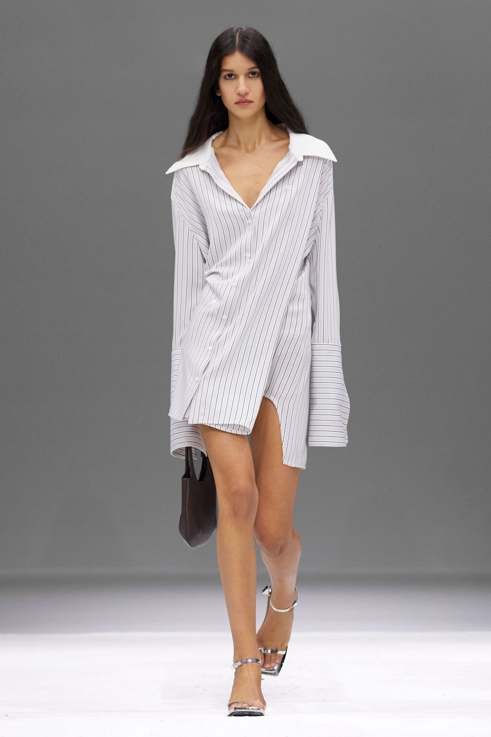Elegant model in a striped Courrèges shirt dress, showcasing contemporary fashion for ecommerce.