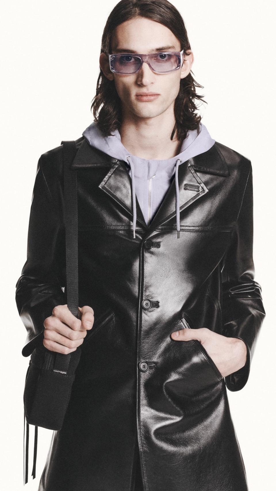 Elegant male model wearing Courrèges black leather jacket and stylish sunglasses.