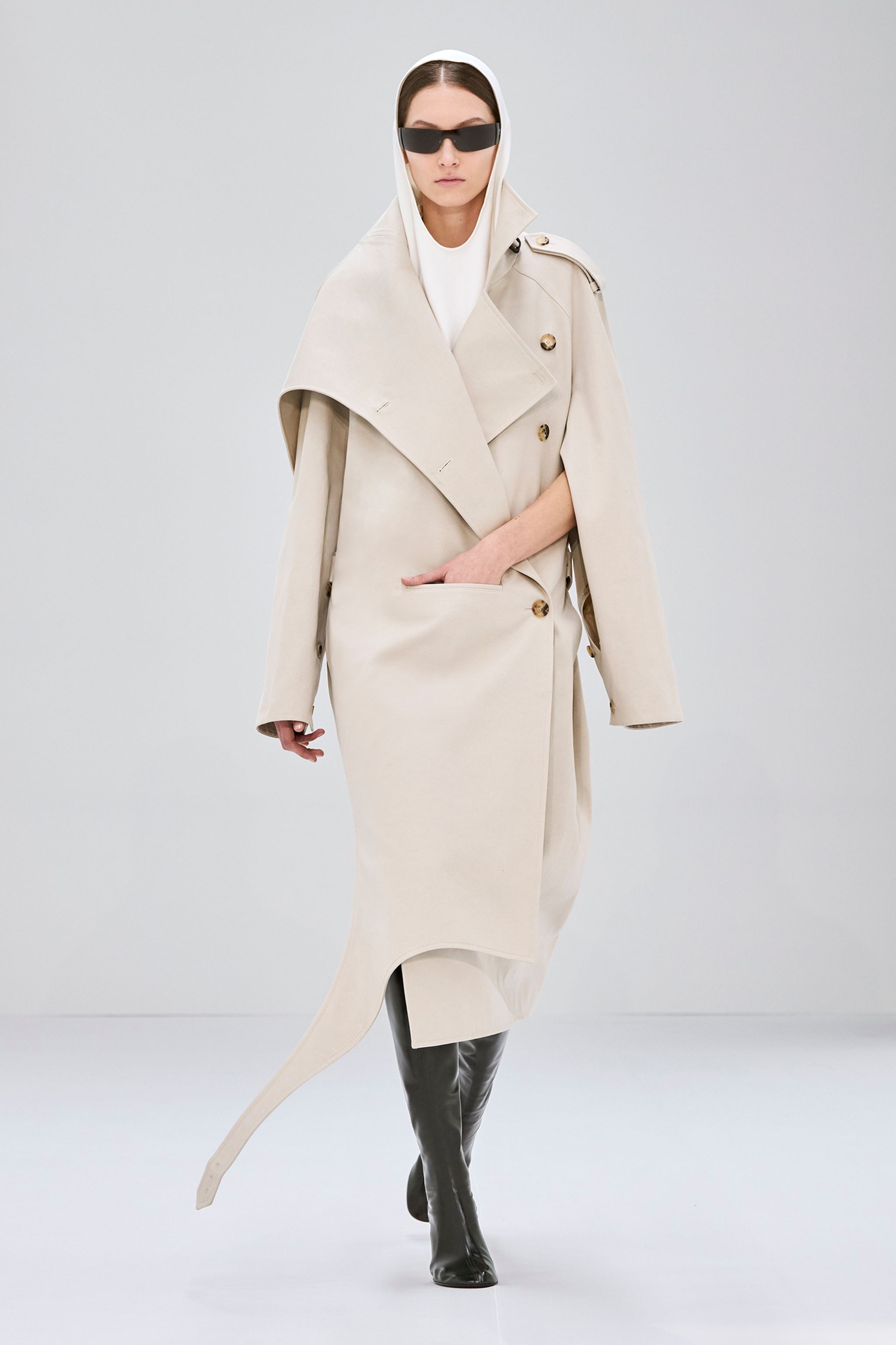 Elegant beige trench coat with asymmetric design, part of Courrèges fashion collection.