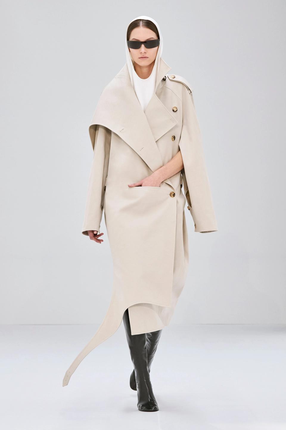 Elegant beige trench coat with asymmetric design, part of Courrèges fashion collection.