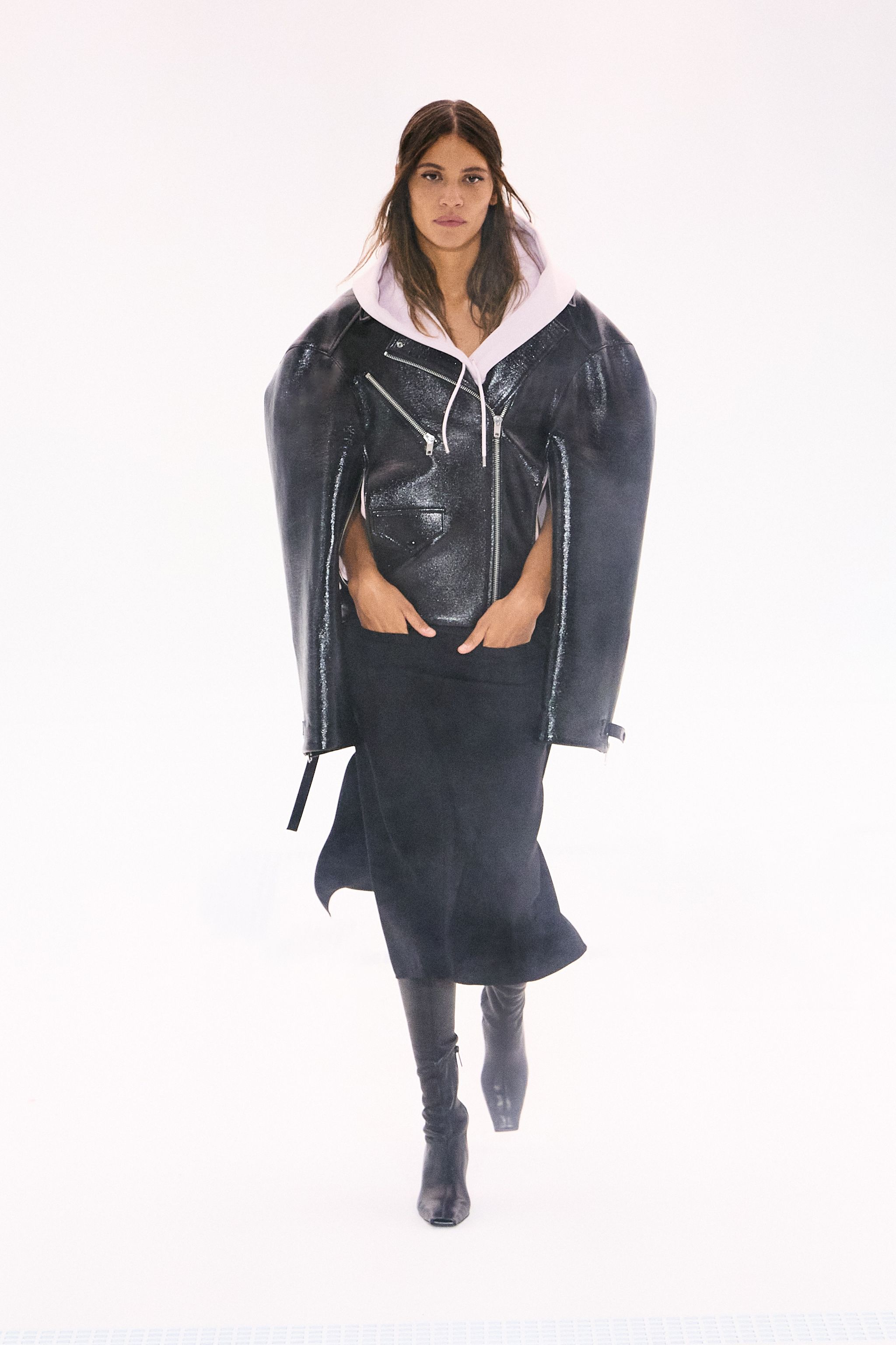 Elegant black leather jacket layered over a white hoodie, showcasing Courrèges fashion.