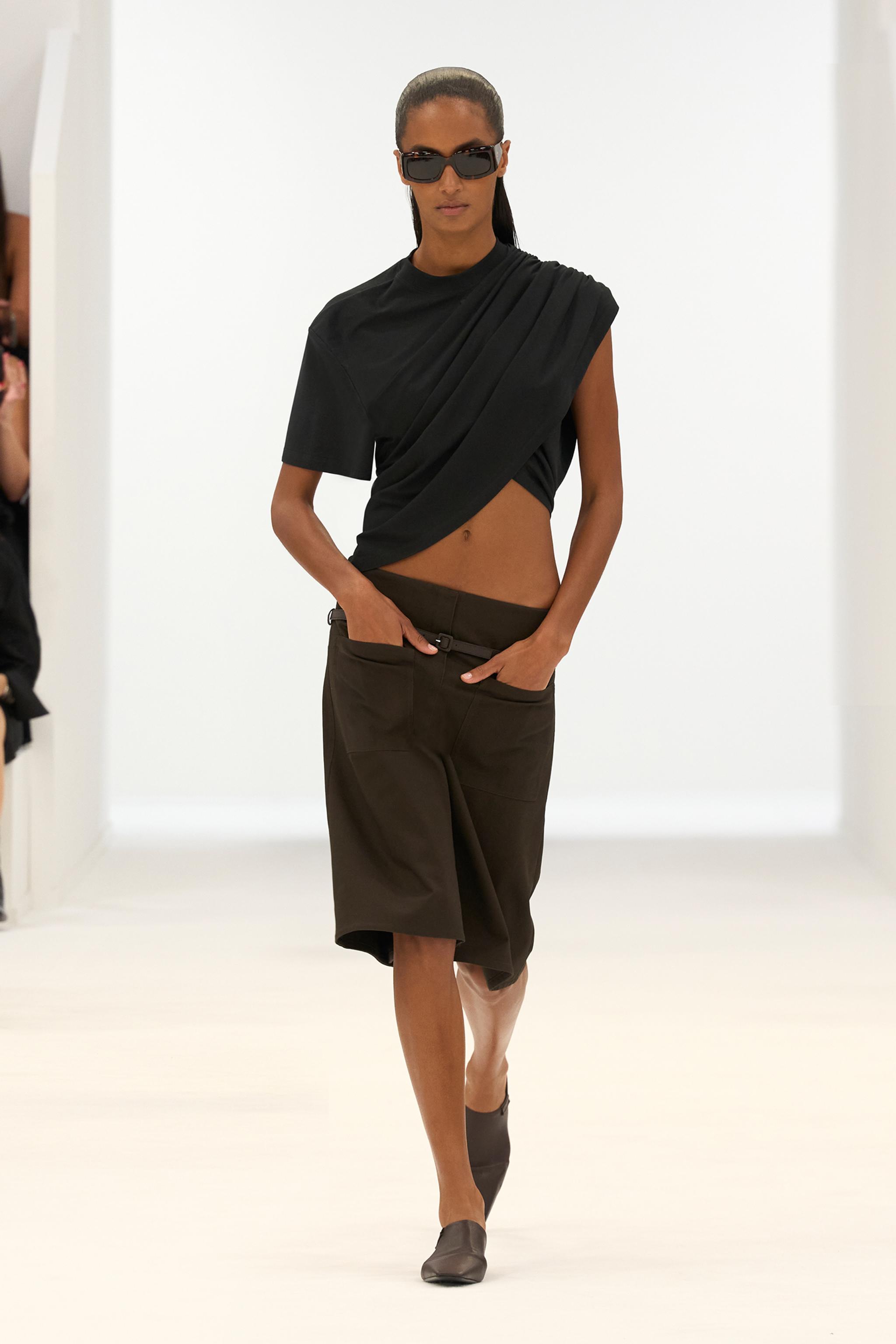 Elegant black asymmetrical top paired with brown wide-leg trousers for Courrèges fashion.