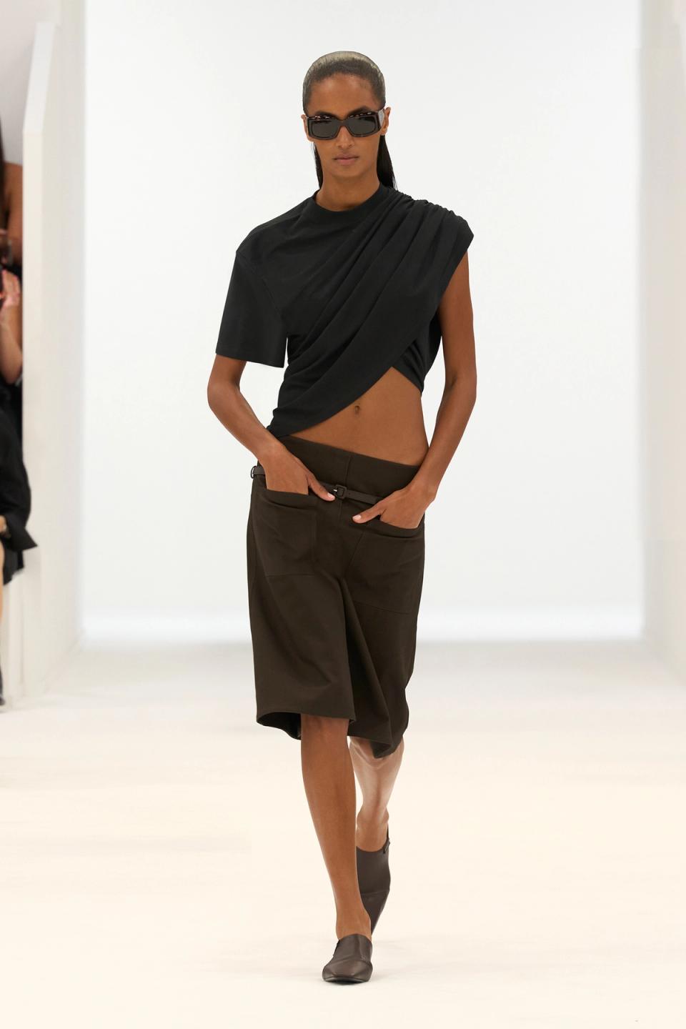 Elegant black fashion outfit from Courrèges displayed on a runway model for an ecommerce site.