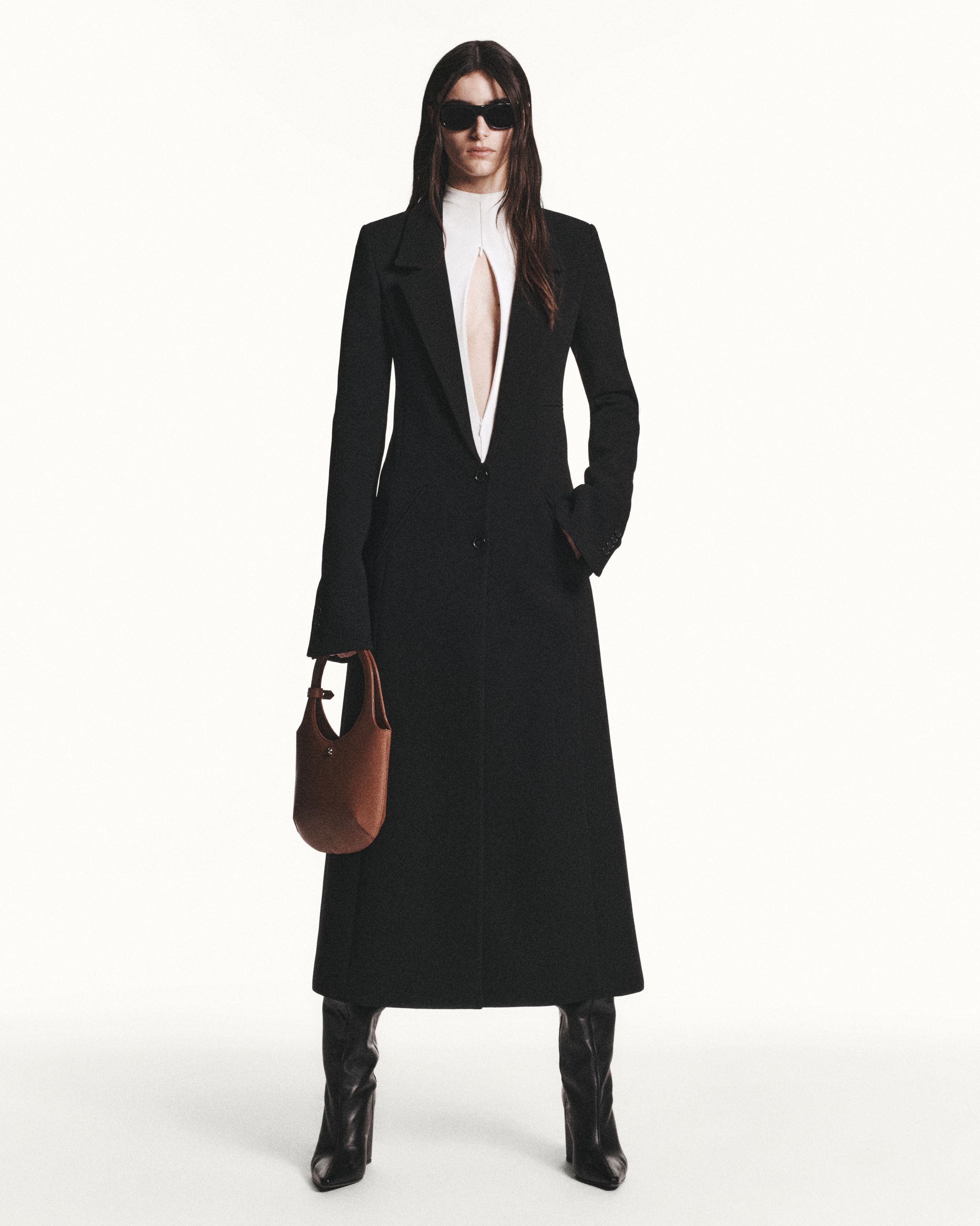 Elegant black tailored coat with a white top, stylish sunglasses, and a brown handbag for Courrèges.