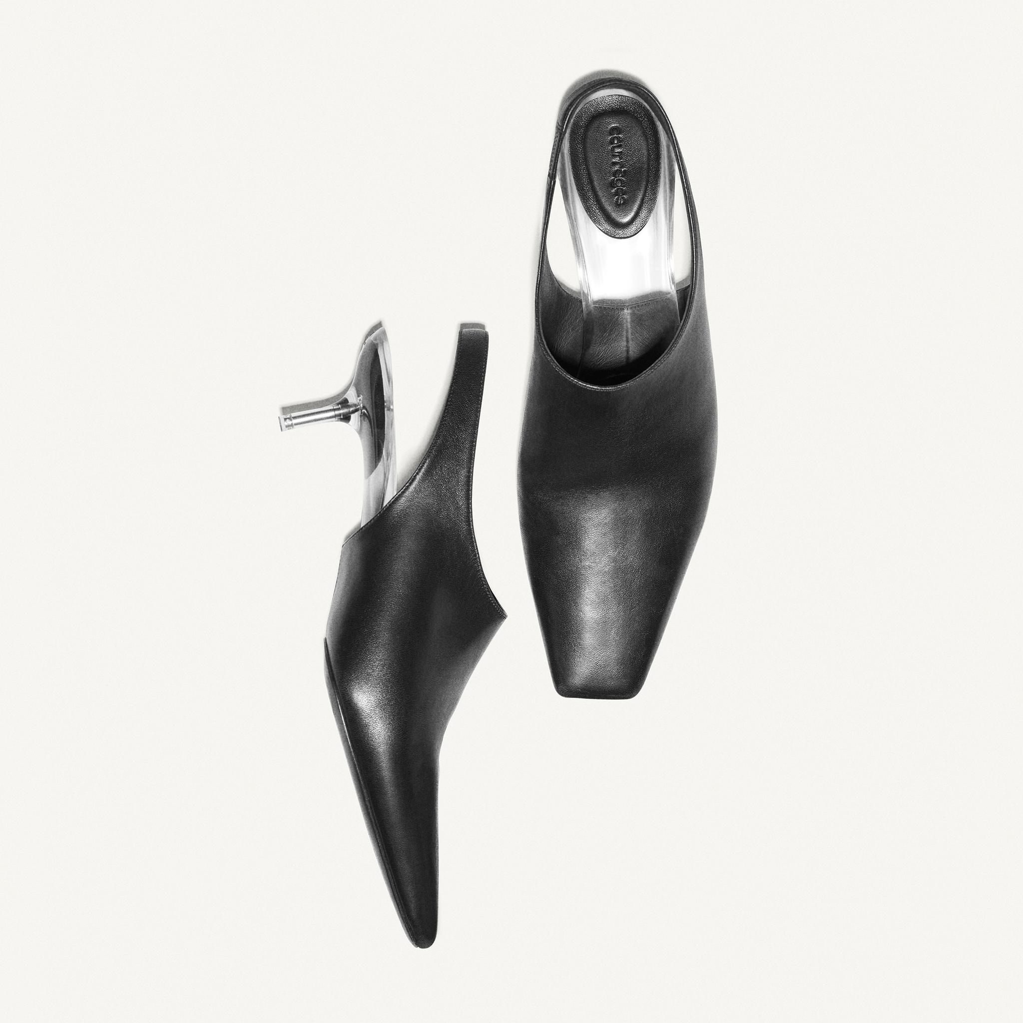 Elegant black leather mules with clear heels from Courrèges, perfect for a chic look.