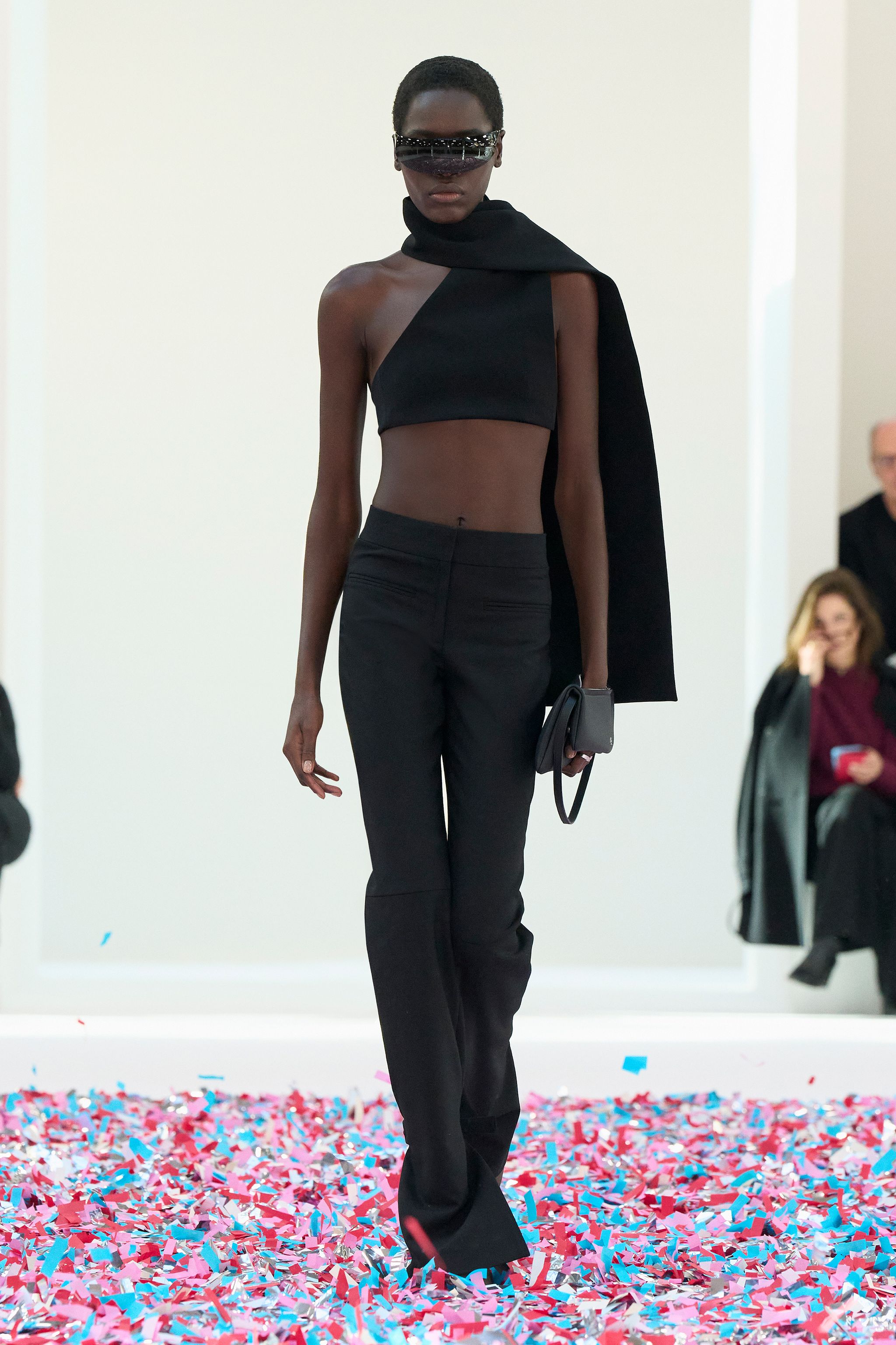 Elegant black fashion ensemble featuring a crop top, tailored pants, and stylish accessories for Courrèges.
