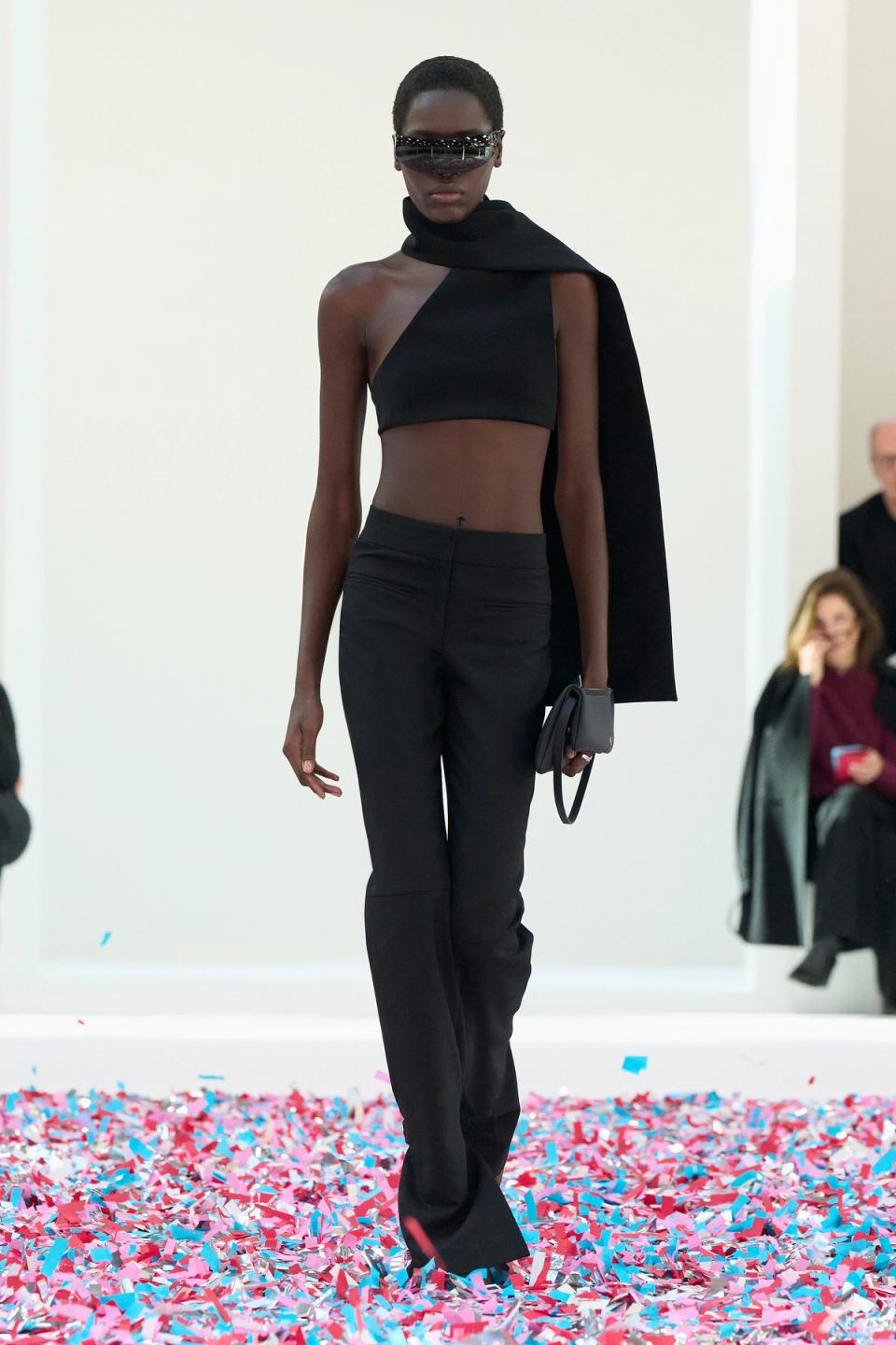 Elegant black fashion ensemble featuring a crop top, tailored pants, and stylish accessories for Courrèges.