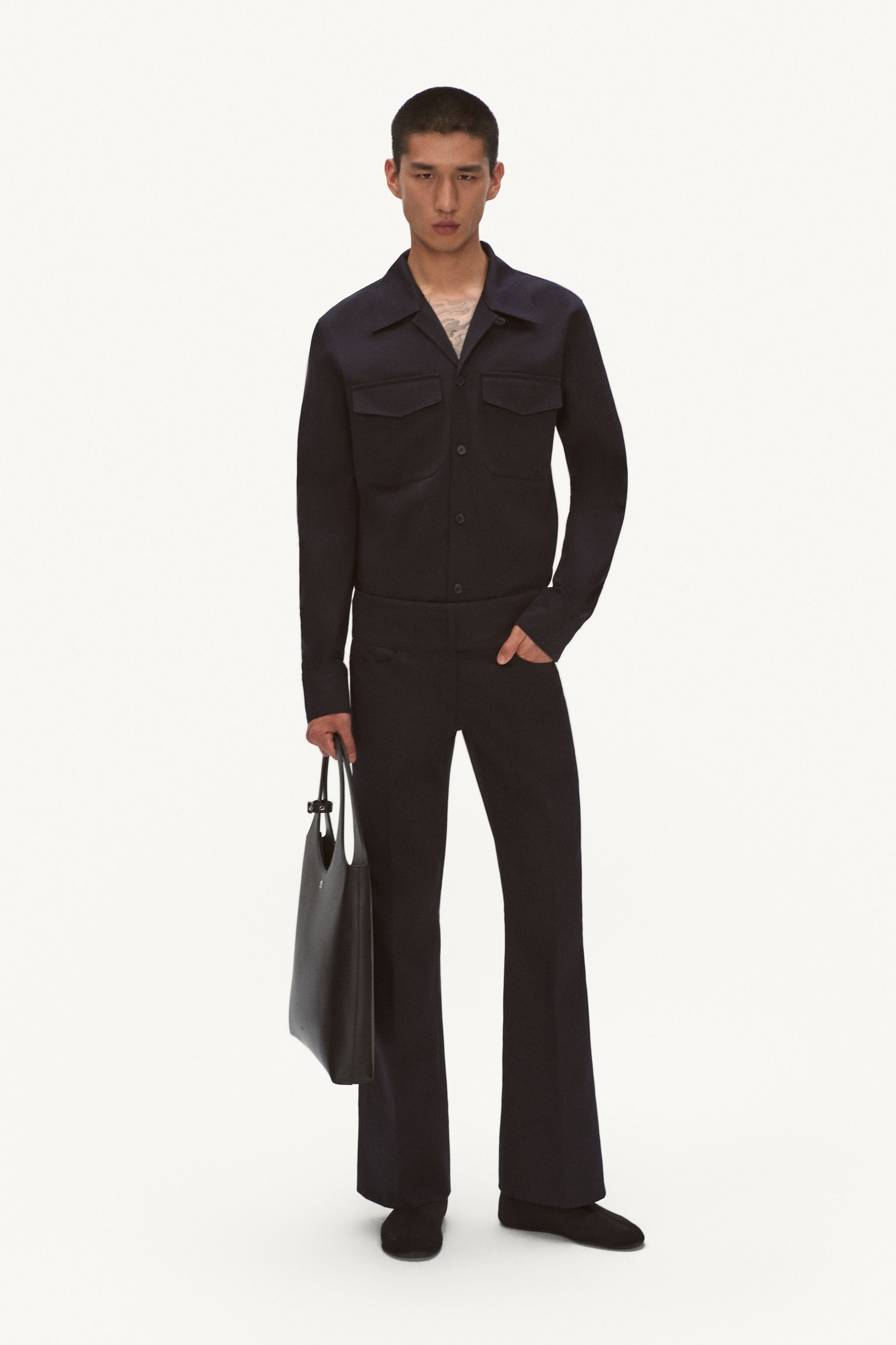 Elegant black fashion ensemble featuring a tailored jacket and flared pants for Courrèges.