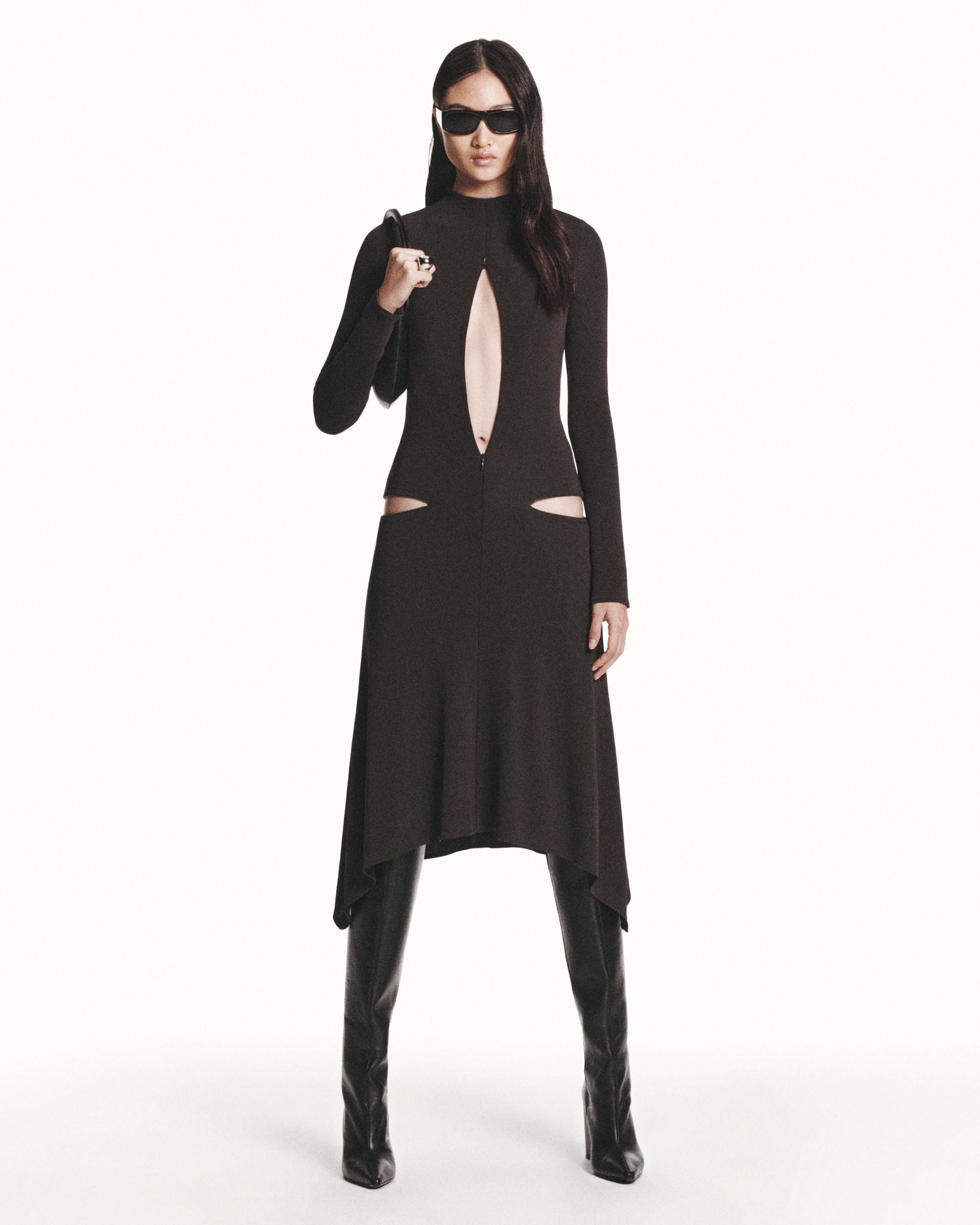 Elegant black dress with cutouts and zipper, styled with sunglasses for Courrèges fashion.
