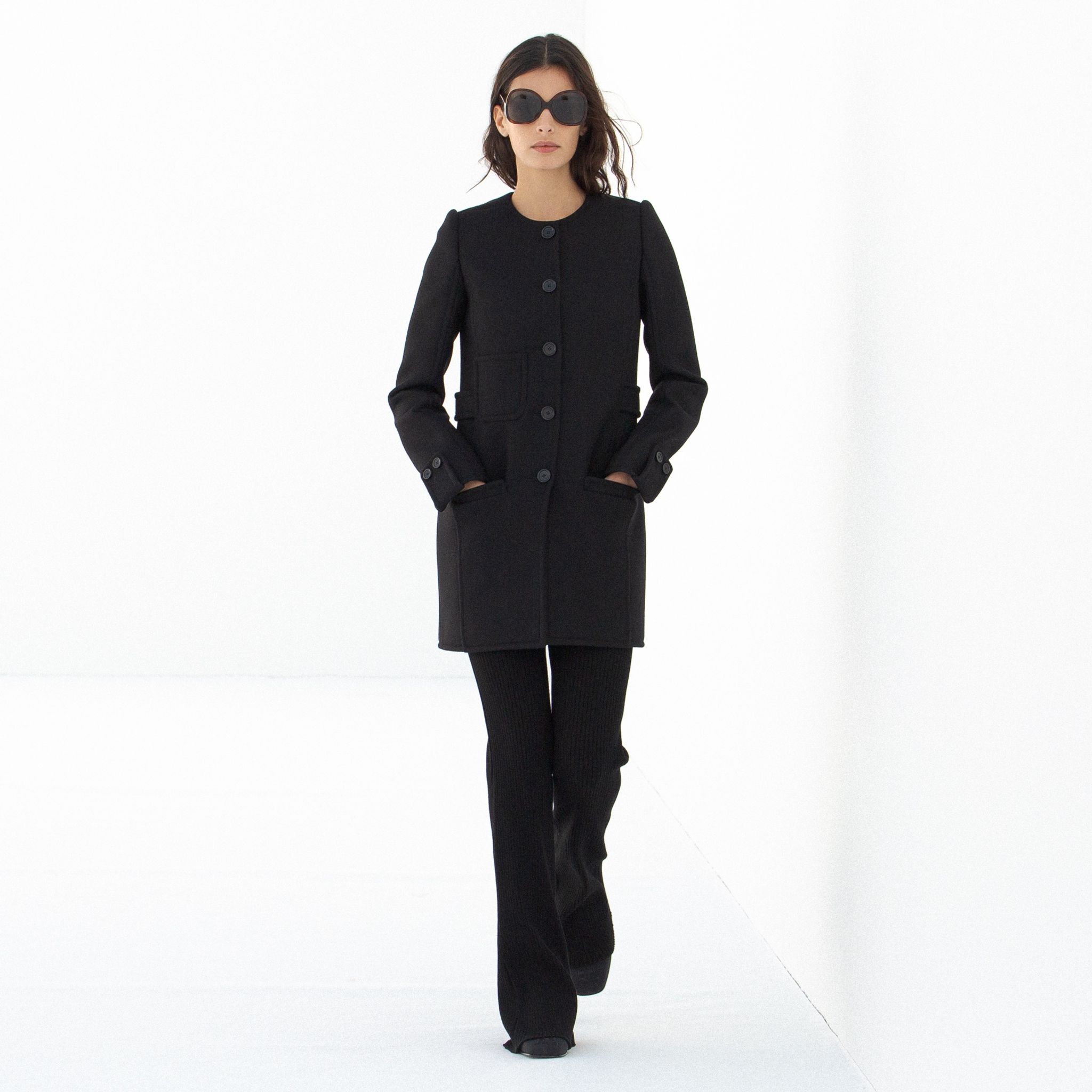 Elegant black tailored coat with large buttons and a modern silhouette, Courrèges fashion piece.