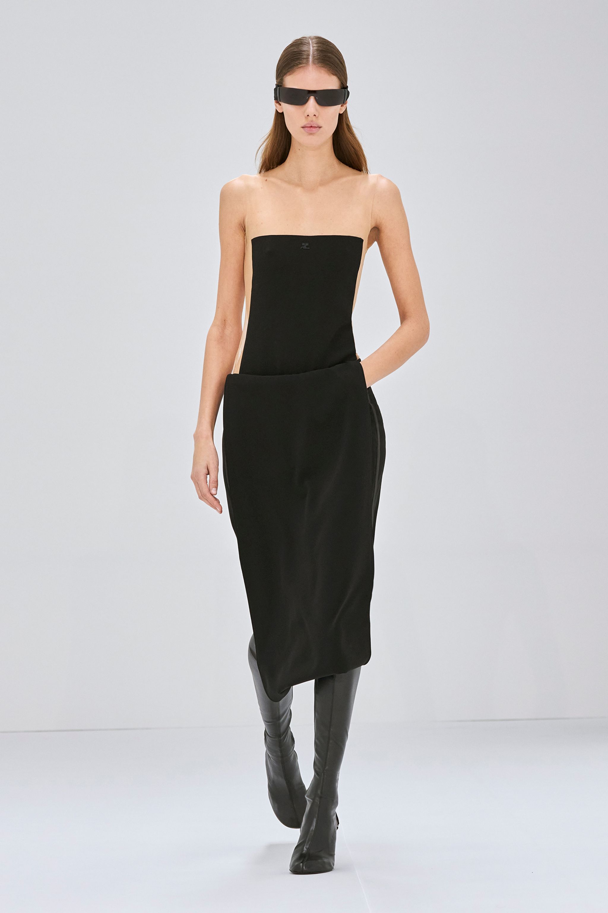 Elegant black strapless dress by Courrèges paired with sleek knee-high boots for fashion.