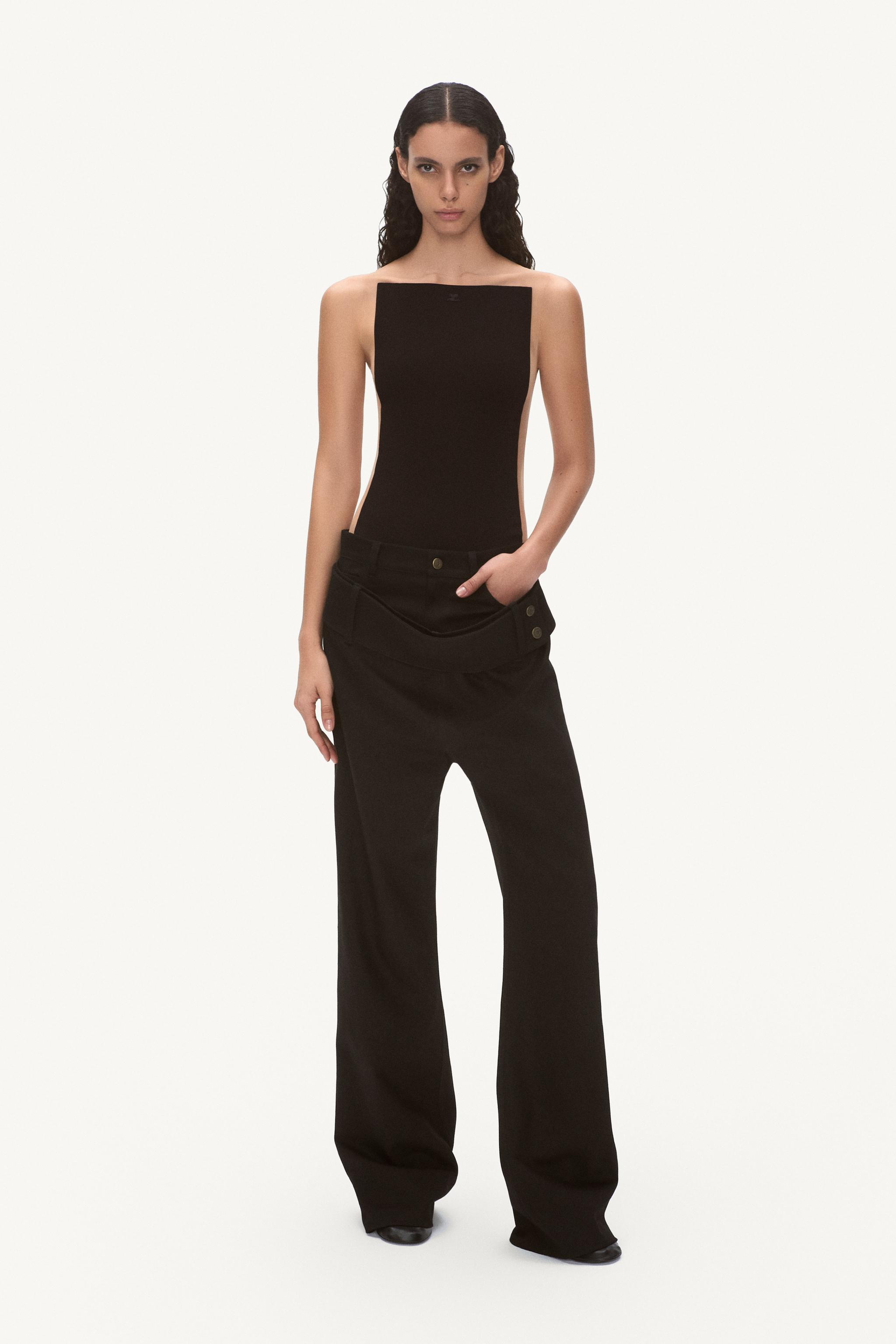 Elegant female model wearing black top and wide-leg pants, showcasing Courrèges fashion.