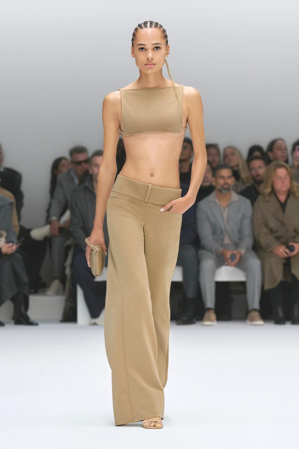 Elegant beige crop top and wide-leg pants showcased on a model at Courrèges fashion show.