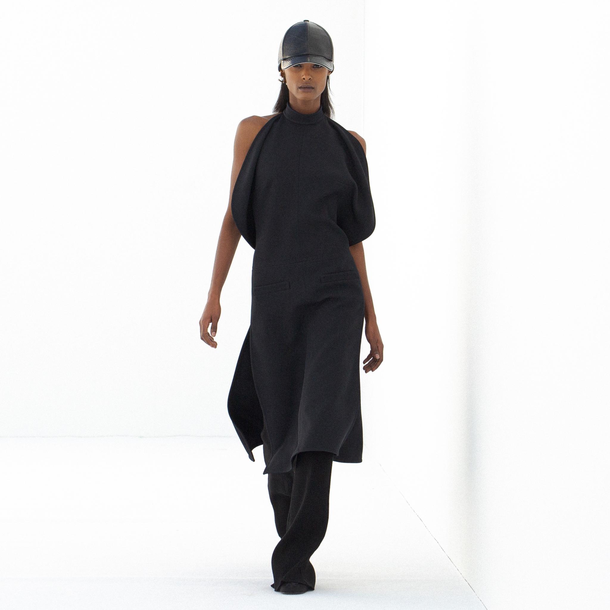 Robe noire élégante à design drapé unique, partie de la collection mode moderne de Courrèges.