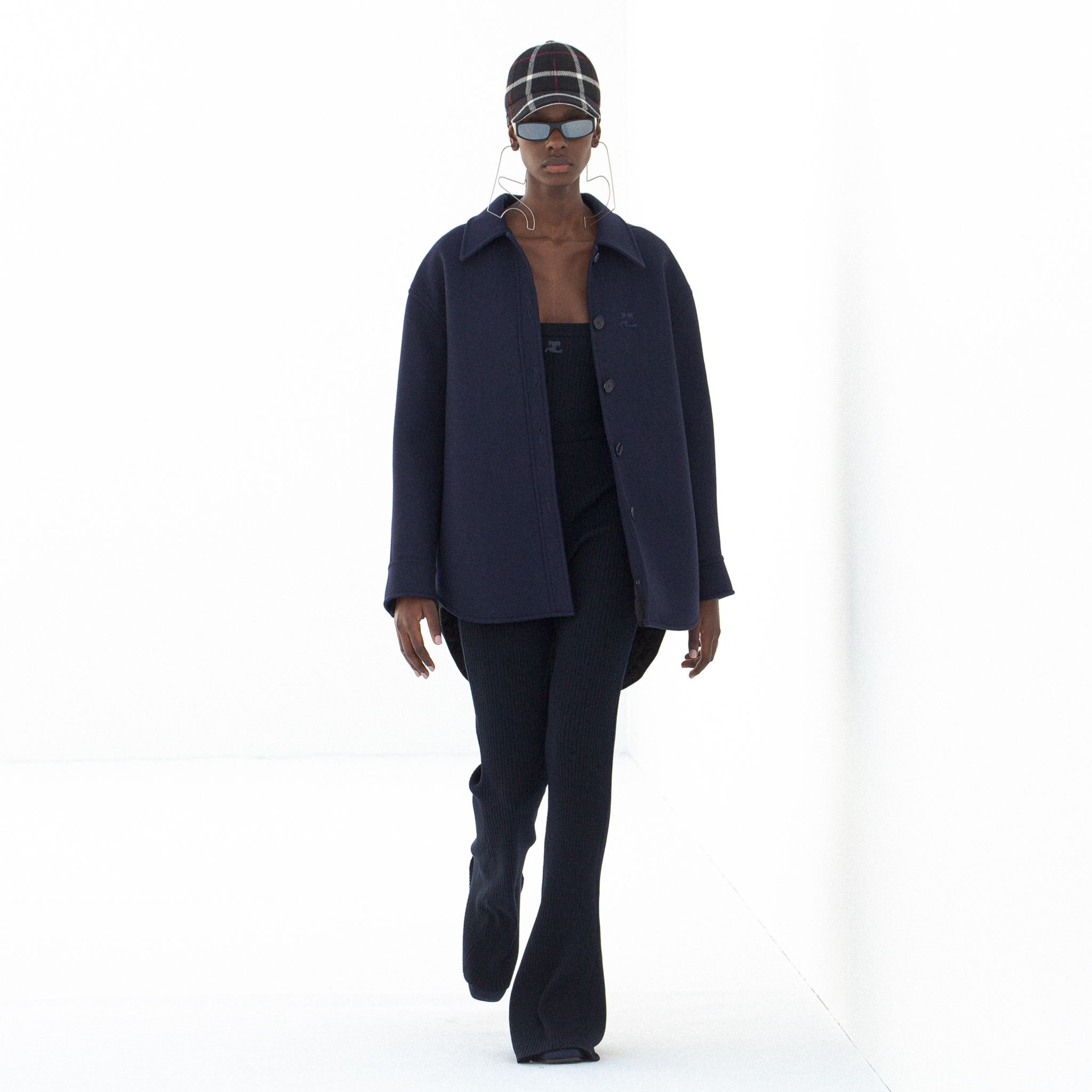 Elegant navy coat and matching sweater, accessorized with stylish sunglasses for Courrèges.