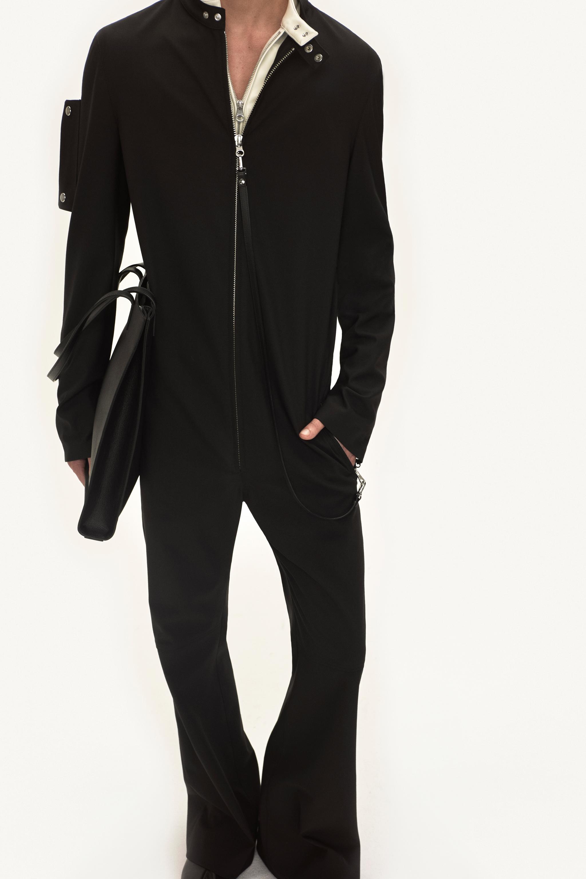 Tenue élégante Courrèges noire avec veste ajustée et pantalon évasé pour un style moderne.