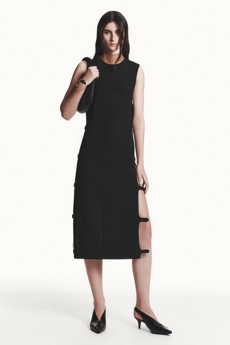 Elegant black dress with side zippers and thigh-high slit, styled for Courrèges fashion.