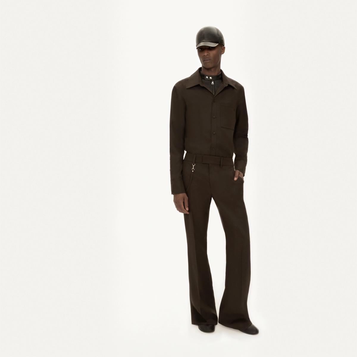 Modèle élégant en tenue sombre avec veste à la mode et pantalon à jambes larges pour Courrèges.