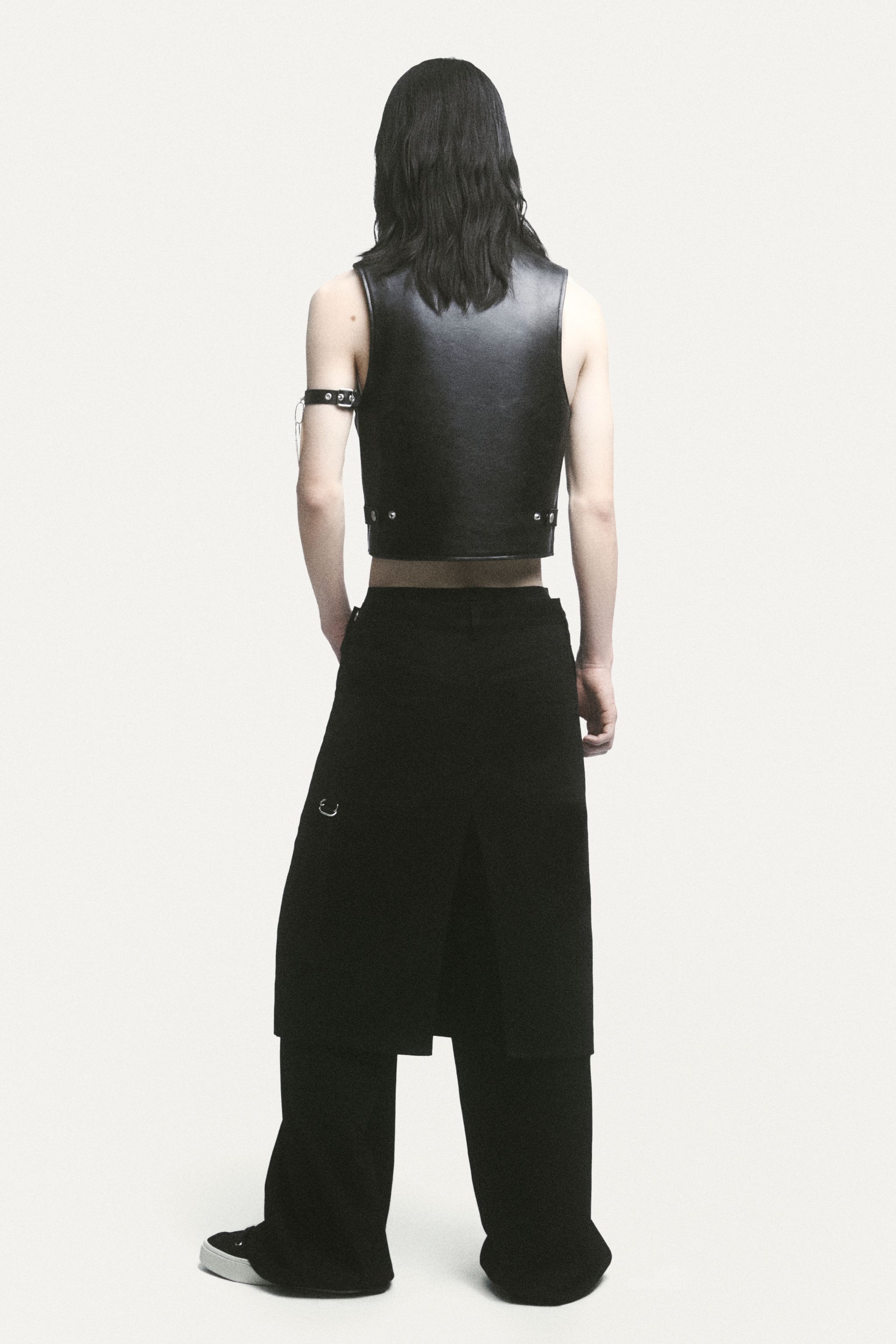 Elegant black leather vest and wide-leg black pants showcased by Courrèges on an ecommerce site.