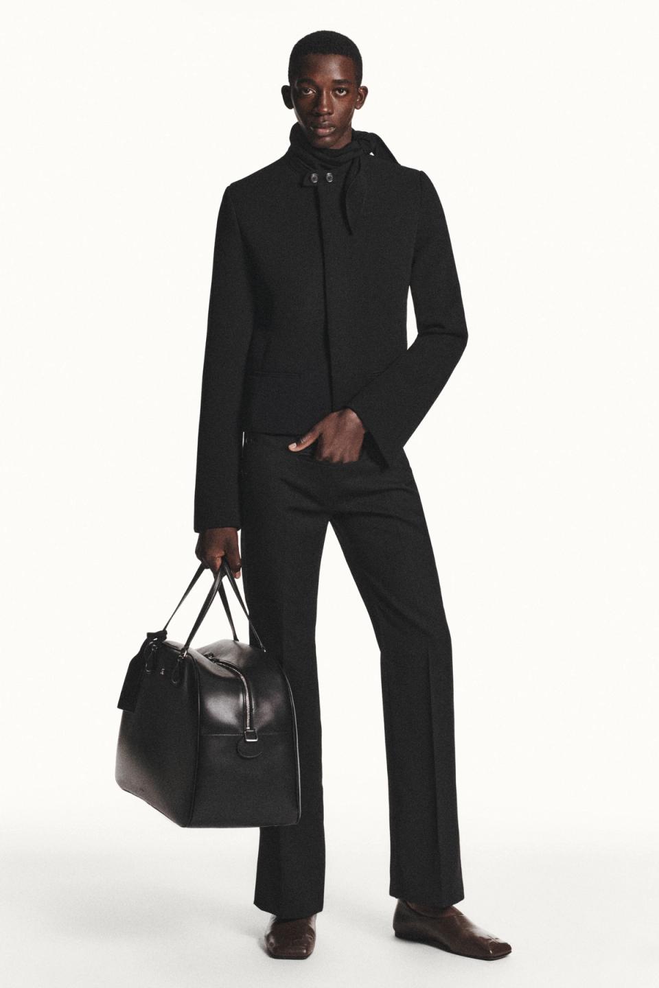 Elegant black business outfit with a sleek blazer, wide-leg pants, and a stylish bag, Courrèges.