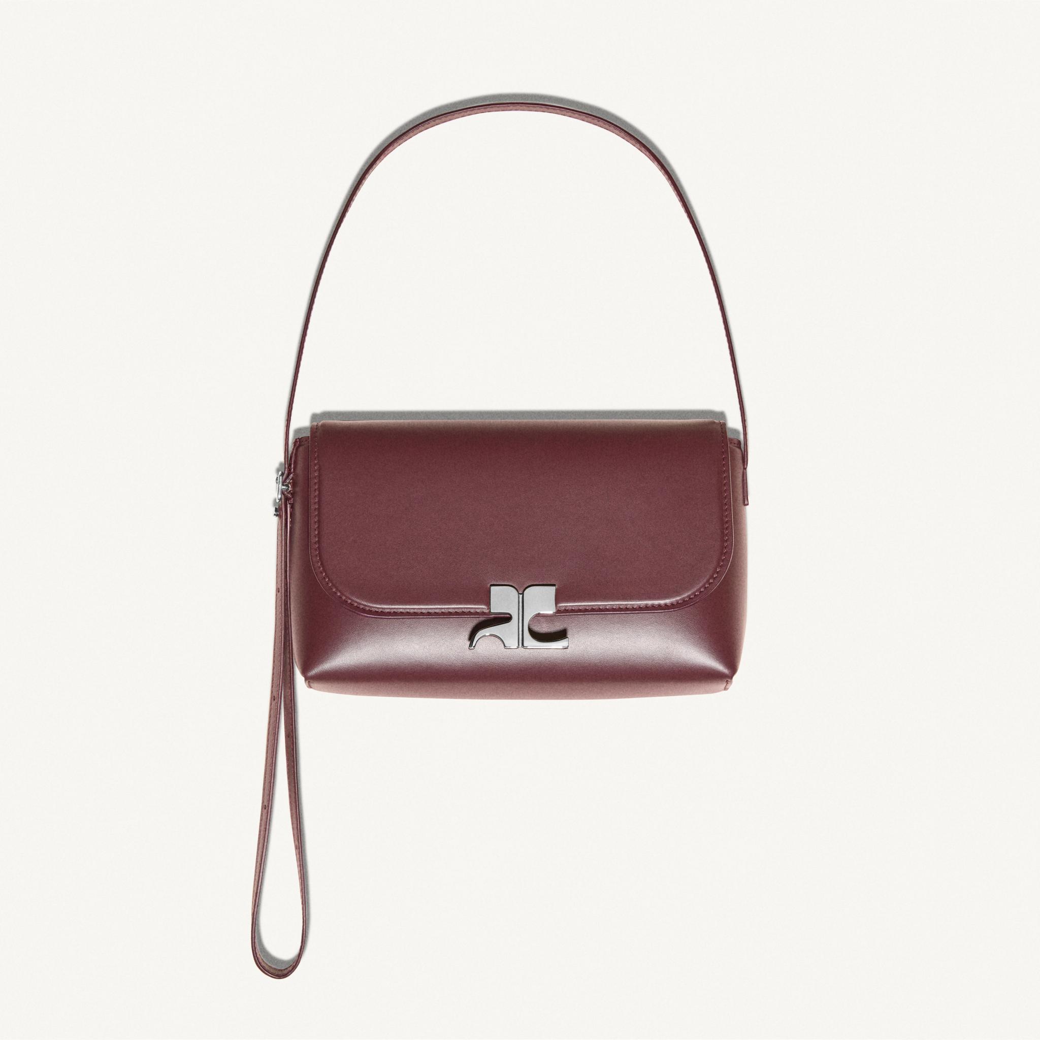 Elegant maroon handbag by Courrèges showcasing minimalist design for fashion enthusiasts.