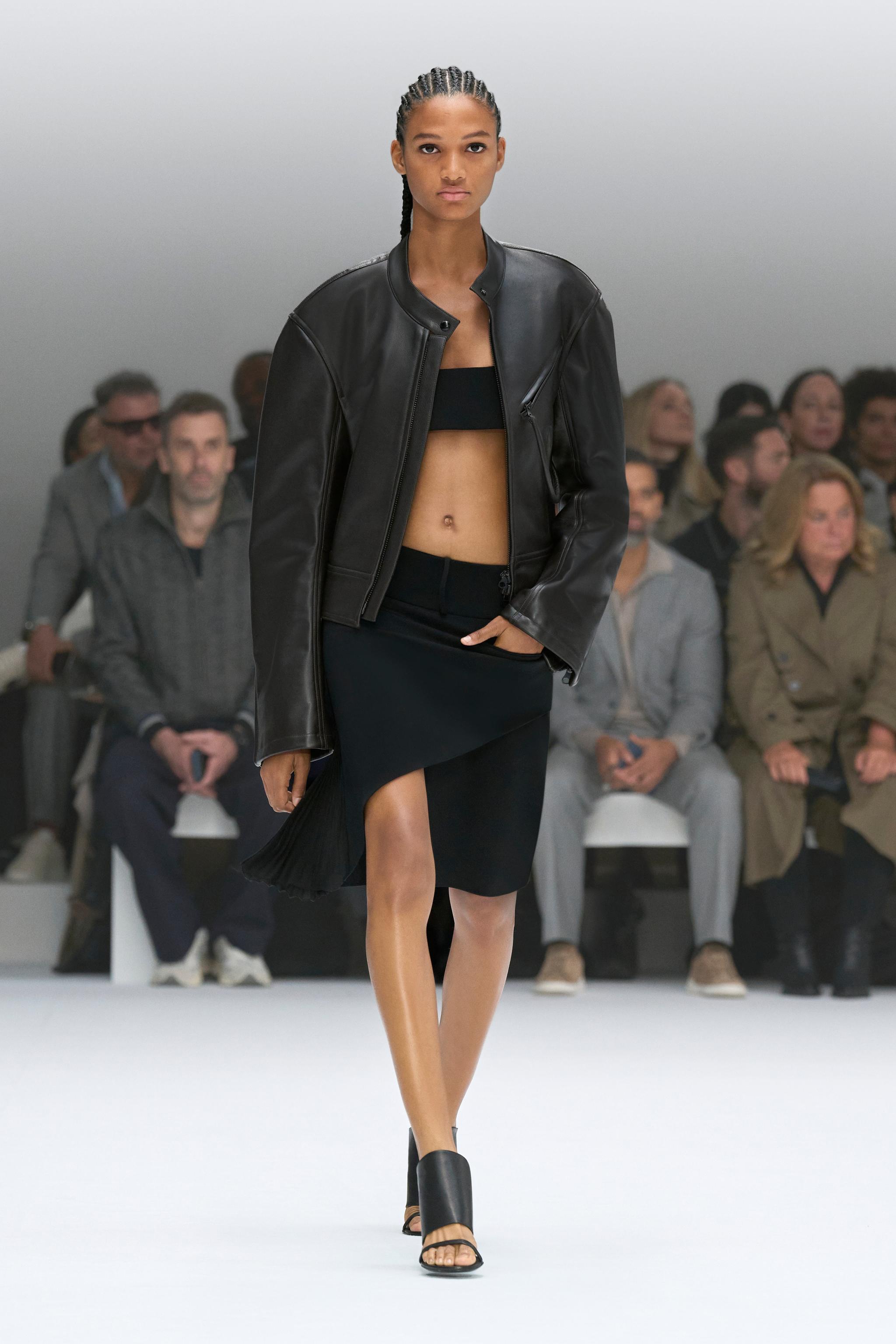 Elegant black leather jacket styled with a modern black skirt for Courrèges fashion showcase.