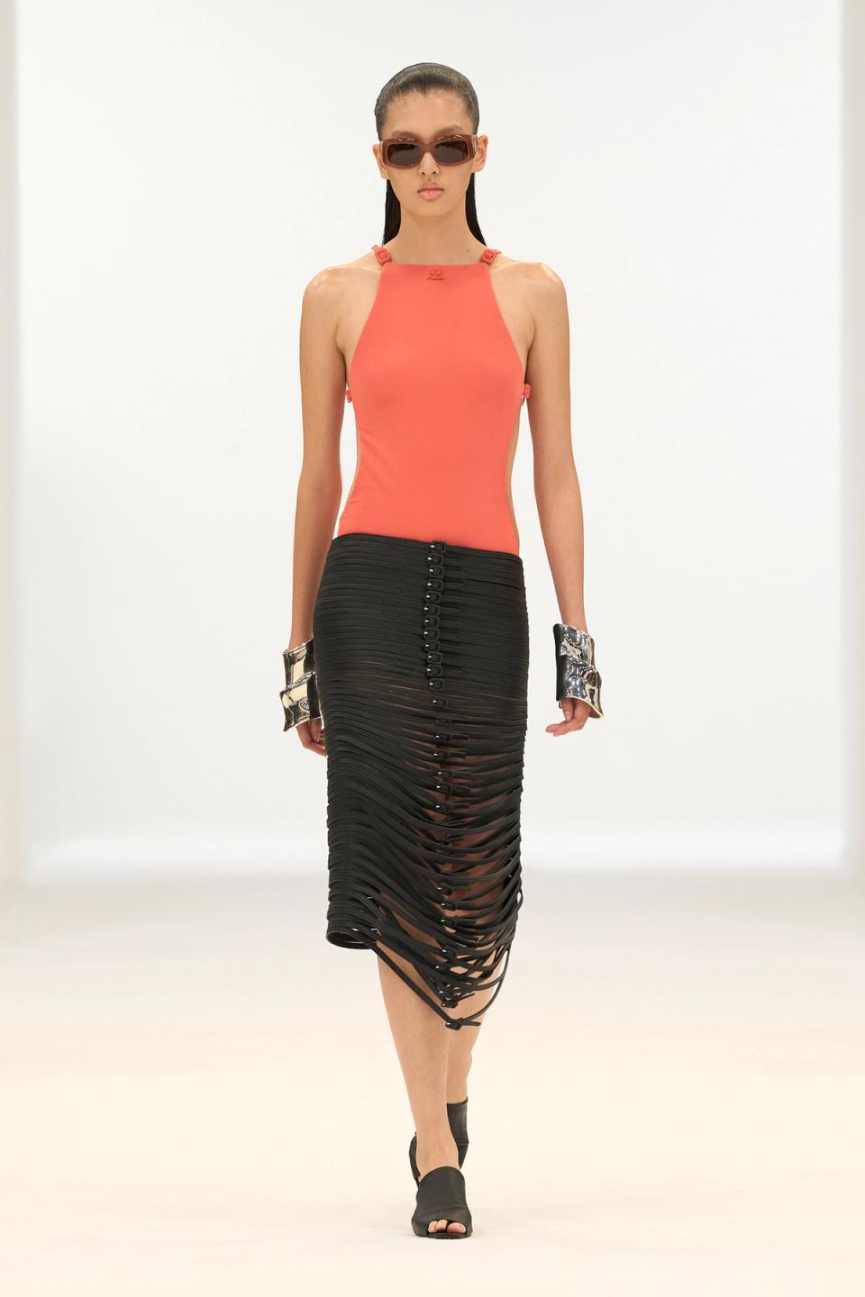 Elegant black and coral fashion ensemble showcasing Courrèges' contemporary style on the runway.