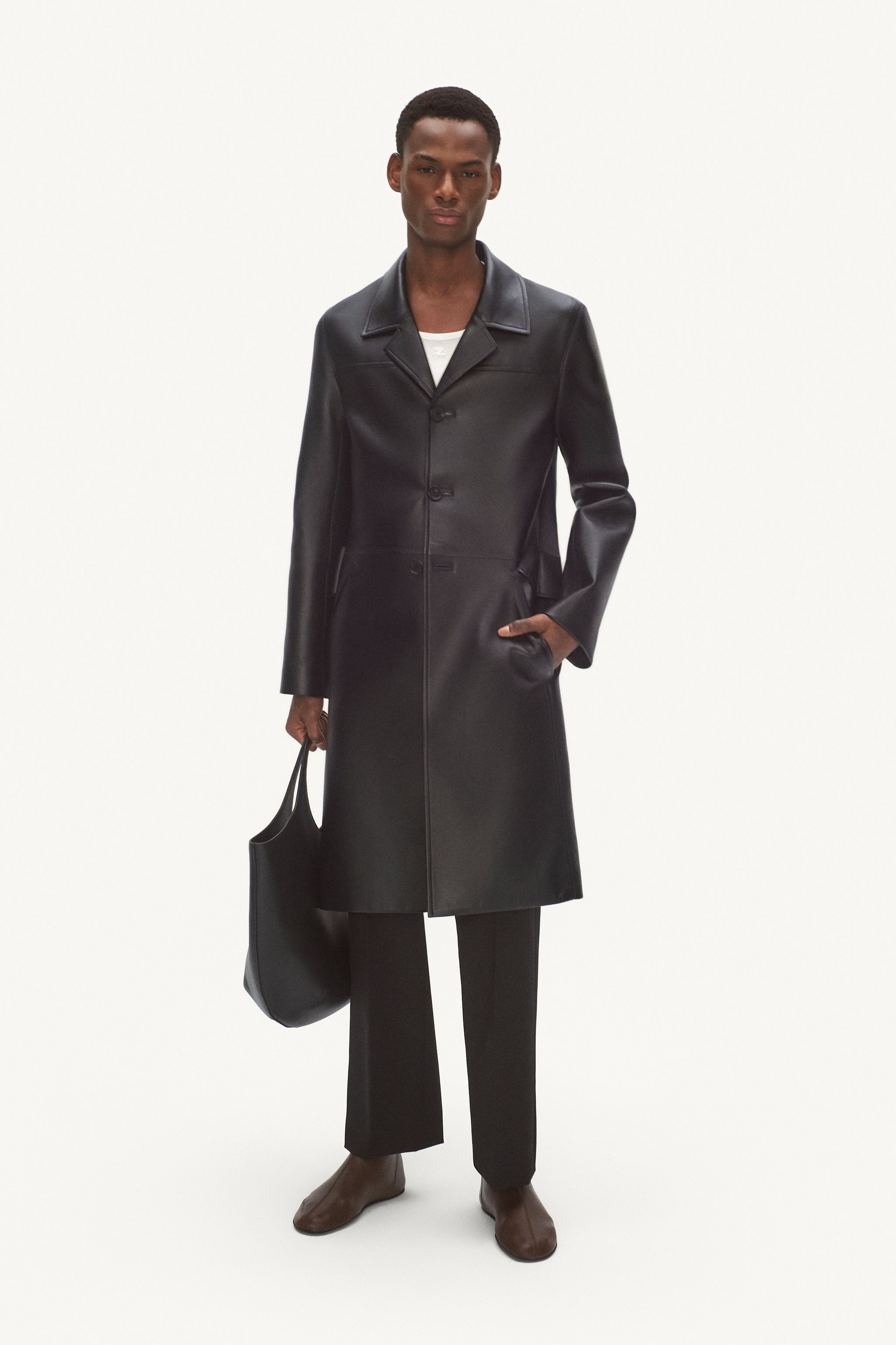 Elegant black leather trench coat with a classic collar, tailored fit, and stylish accessories for Courrèges.