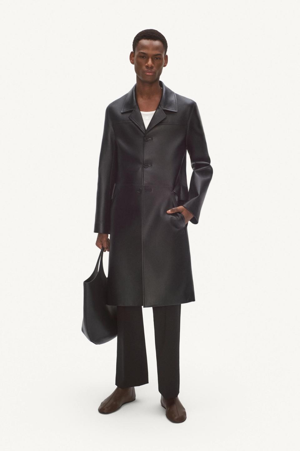 Elegant black leather trench coat with a classic collar, tailored fit, and stylish accessories for Courrèges.