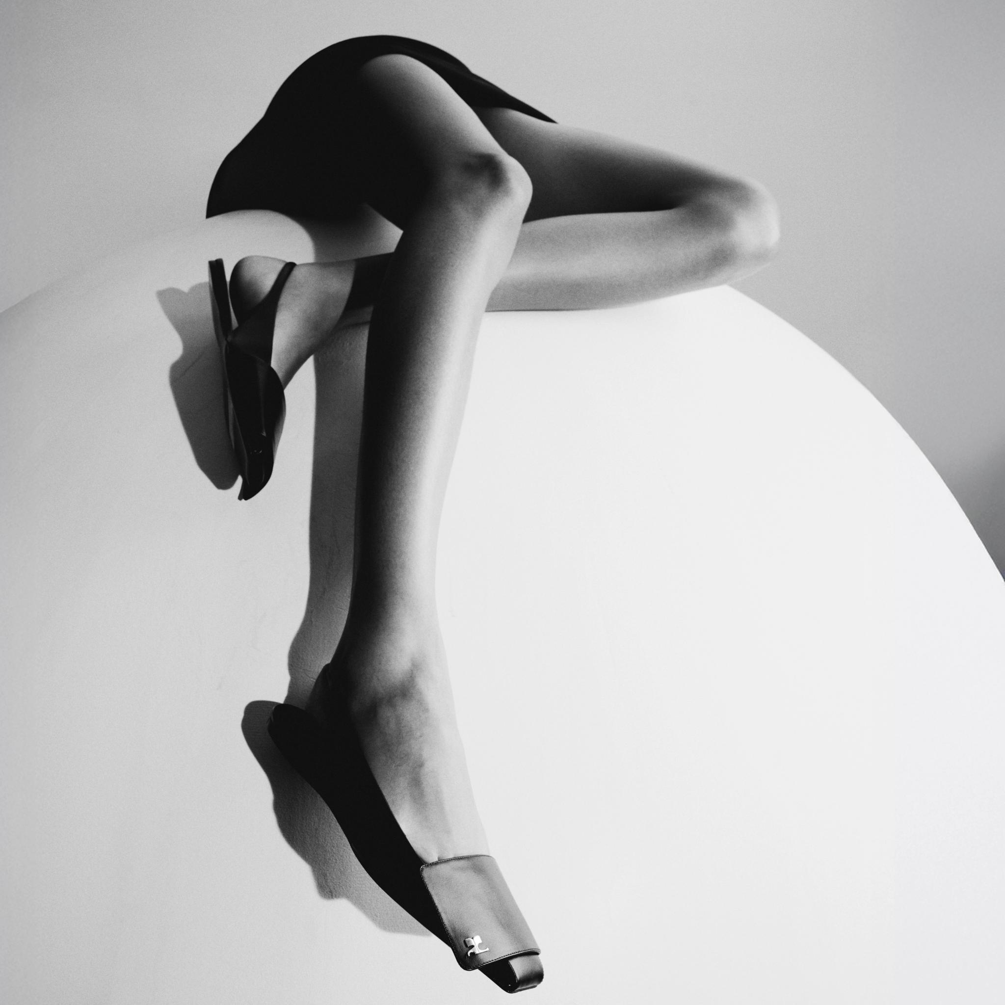 Elegant black high heels, Parisian footwear, showcased for Courrèges on a minimalist white surface.