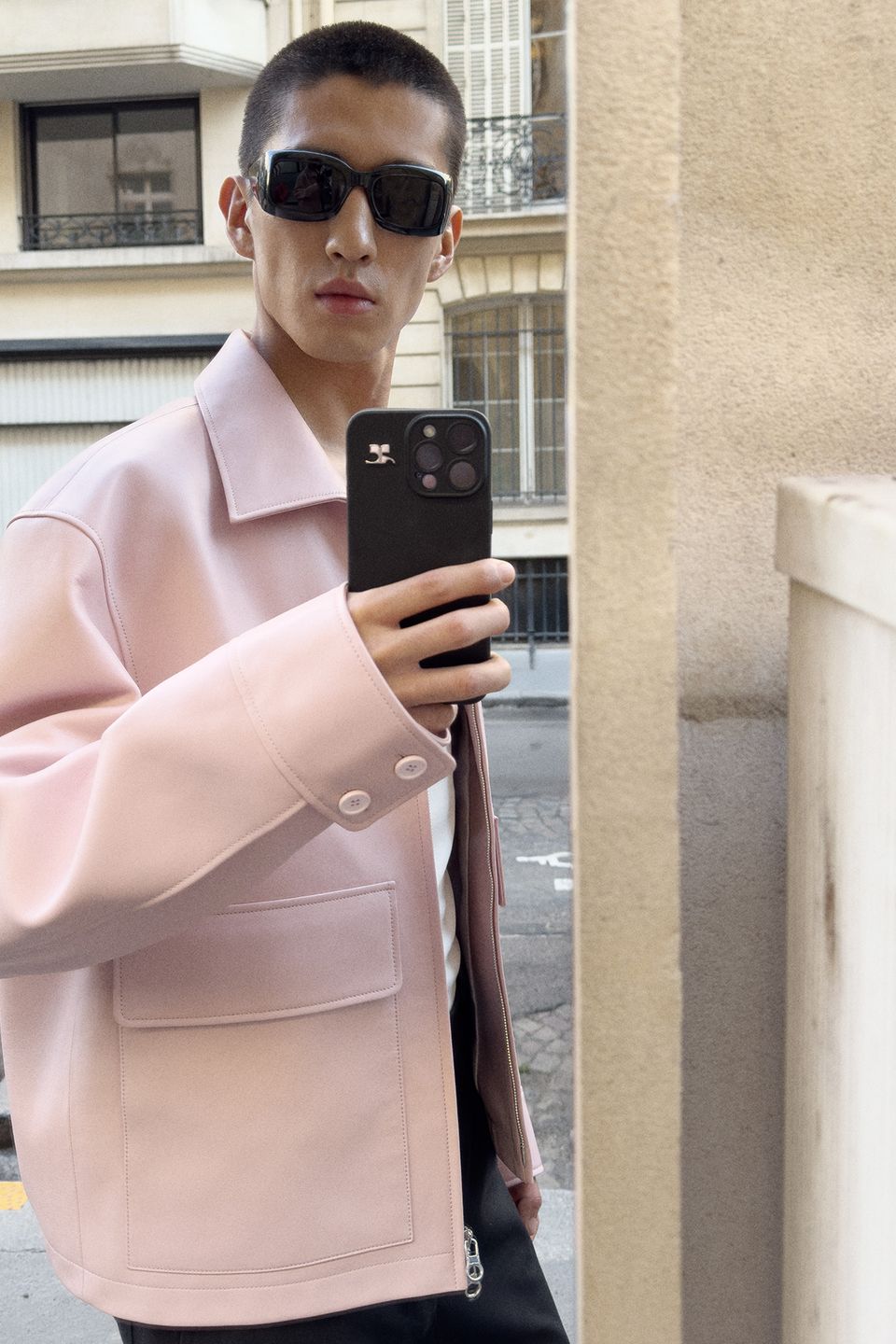 Elegant Courrèges fashion model taking a mirror selfie, showcasing modern style and sunglasses.