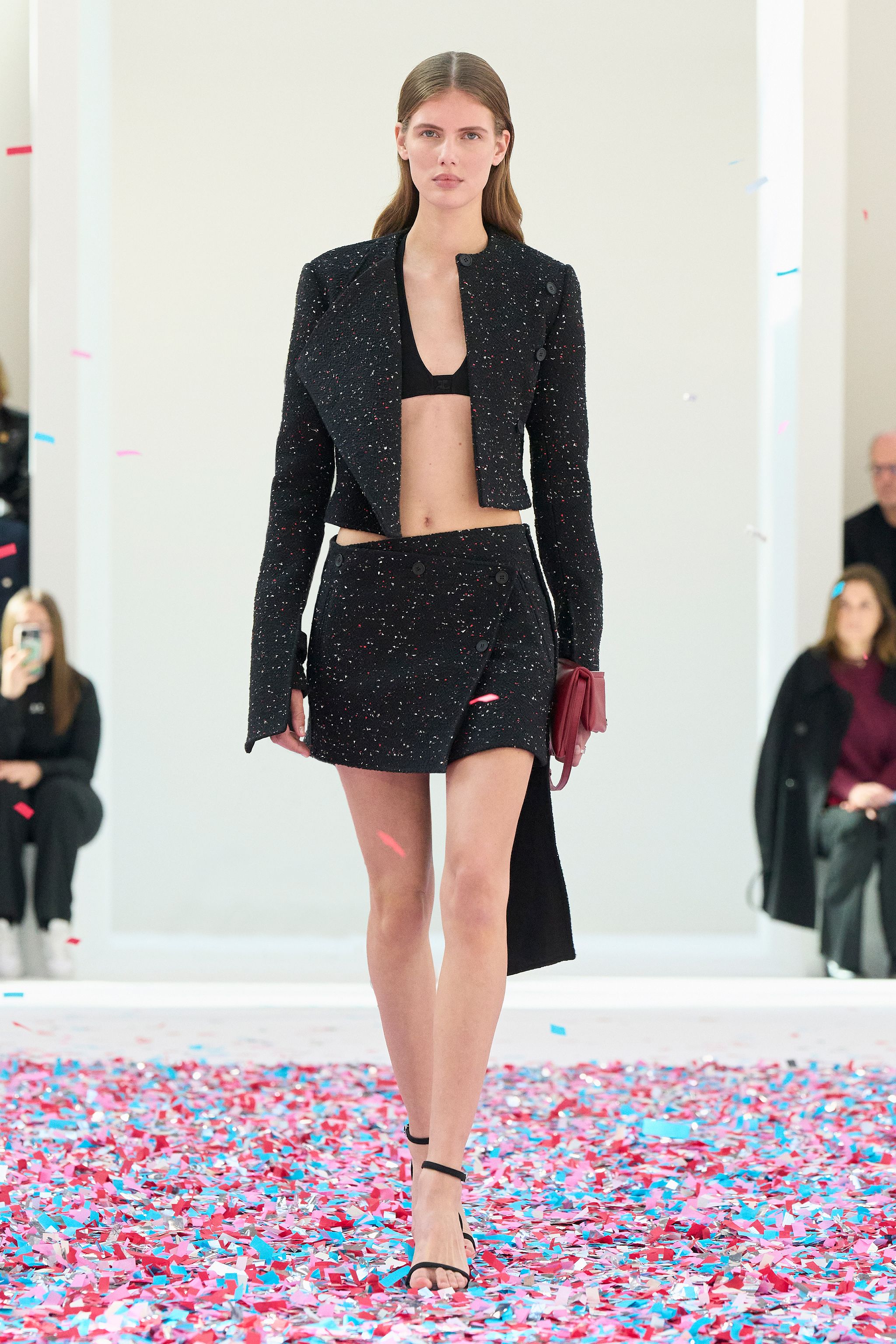 Elegant black cropped jacket and skirt from Courrèges with a modern fashion runway design.