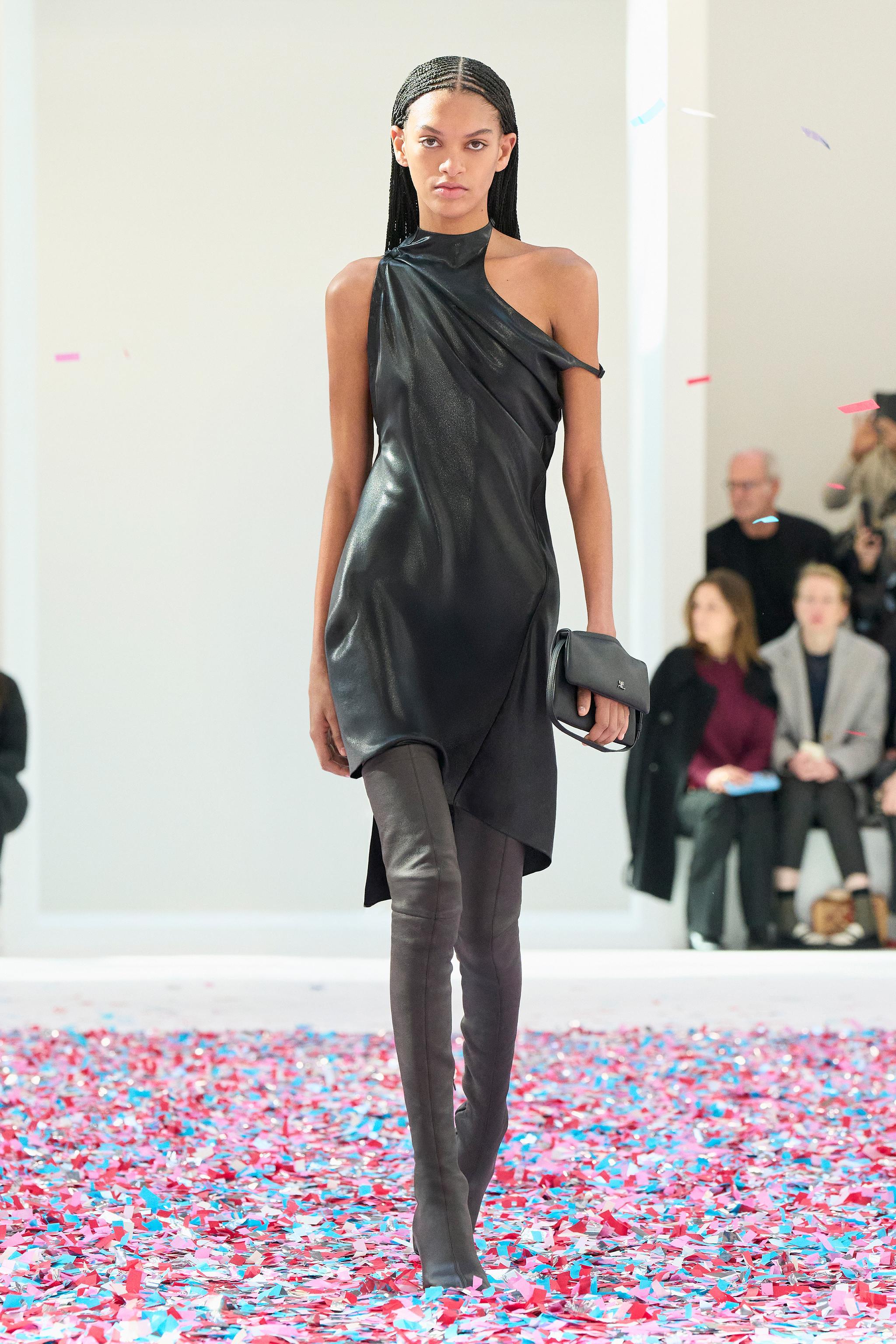 Elegant black leather dress with asymmetrical design by Courrèges, worn on runway.