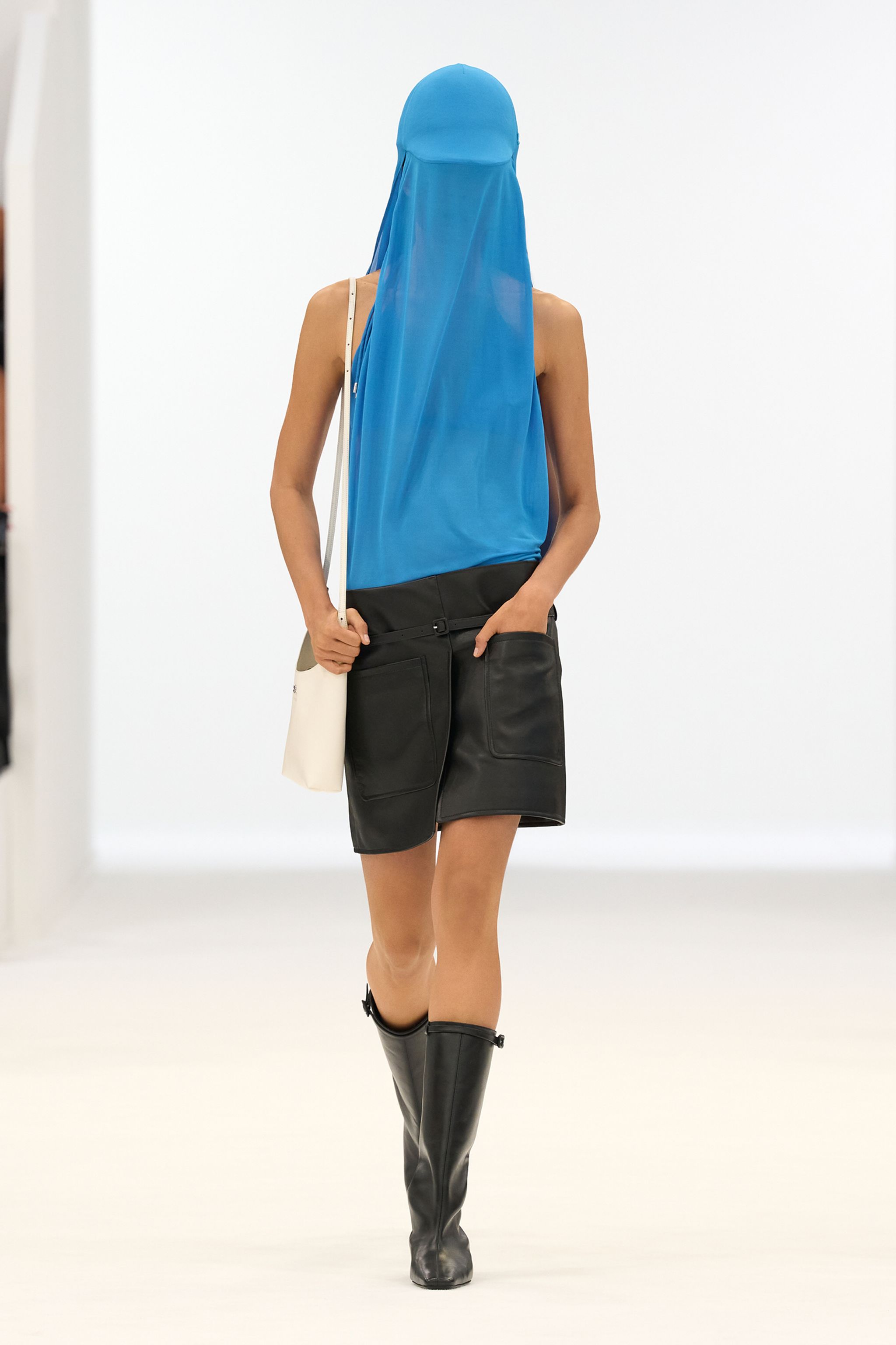 Elegant fashion look featuring a blue veil-inspired top and black leather skirt for Courrèges.
