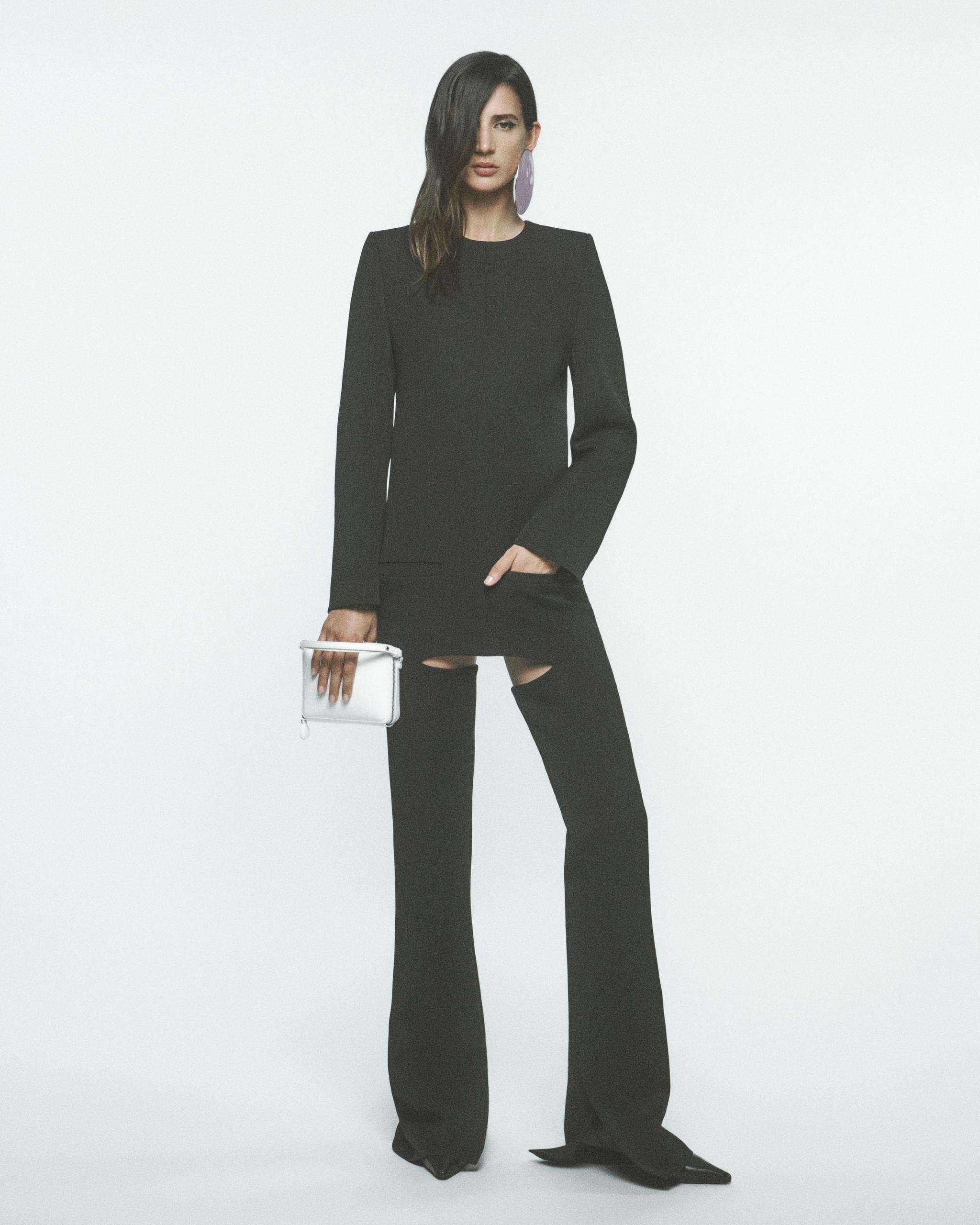 Elegant black Courrèges outfit featuring a tailored blazer, wide-leg pants, and statement earrings.