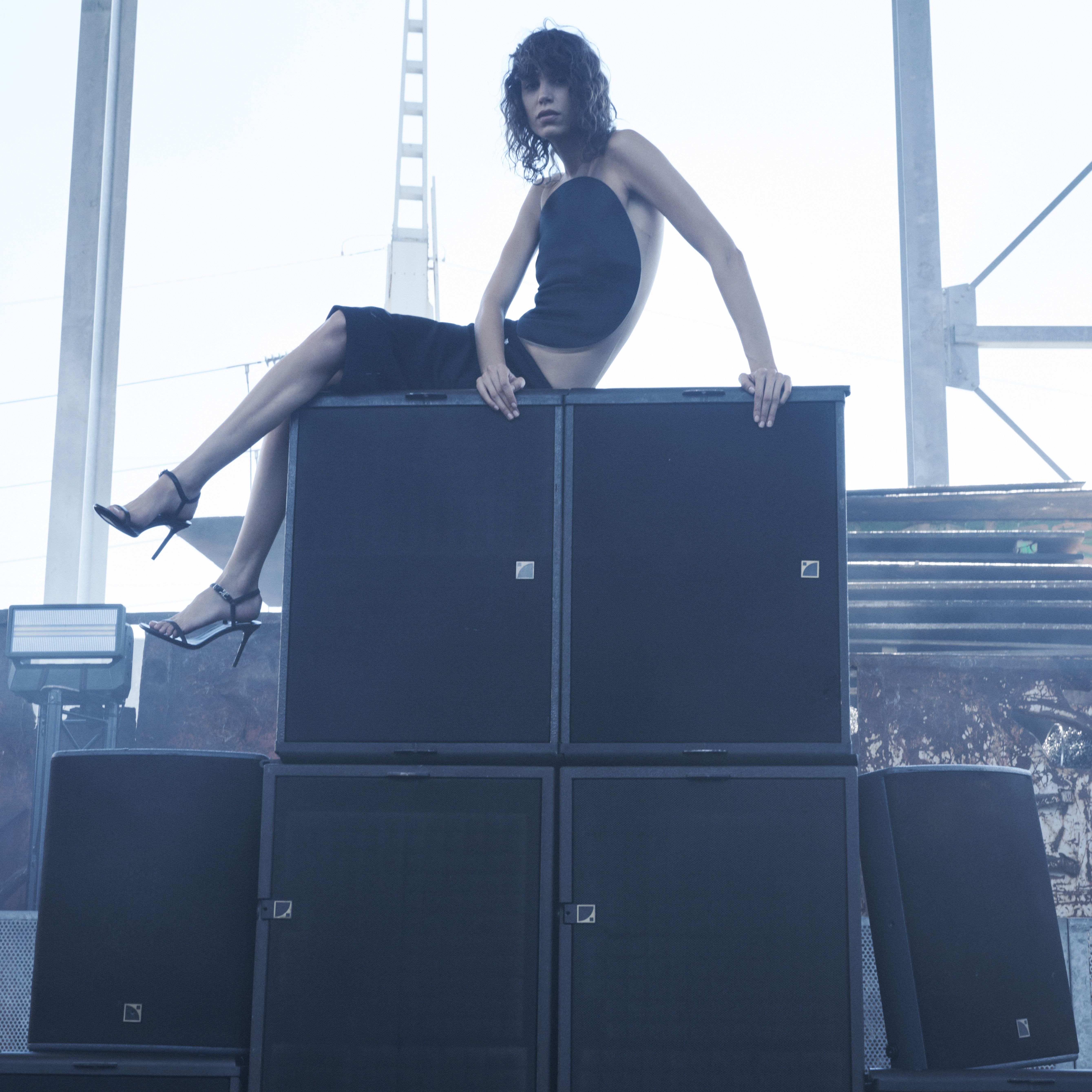 Elegant black dress with thigh-high slit and high heels, showcasing Courrèges fashion.