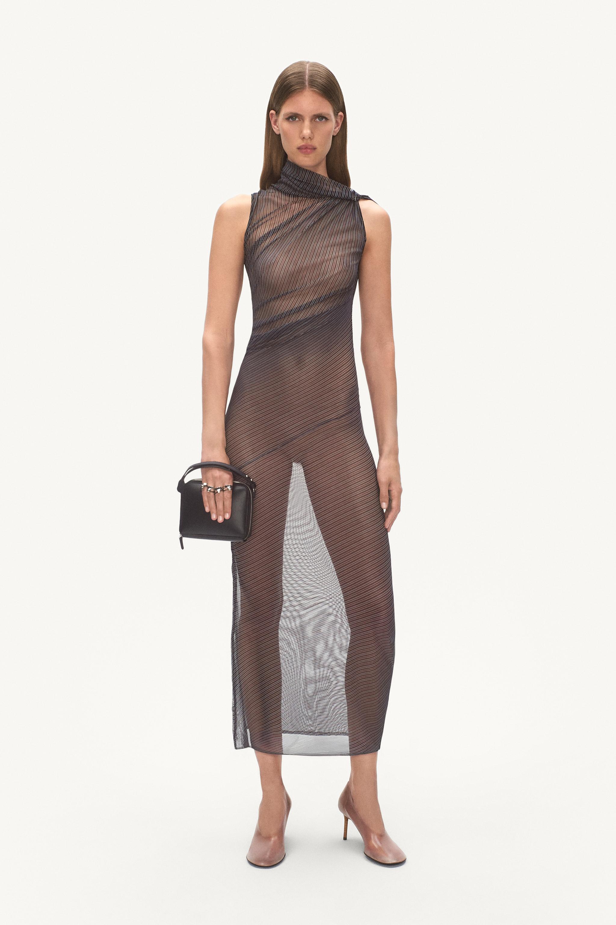 Elegant, sheer striped dress from Courrèges showcasing modern fashion on a runway.