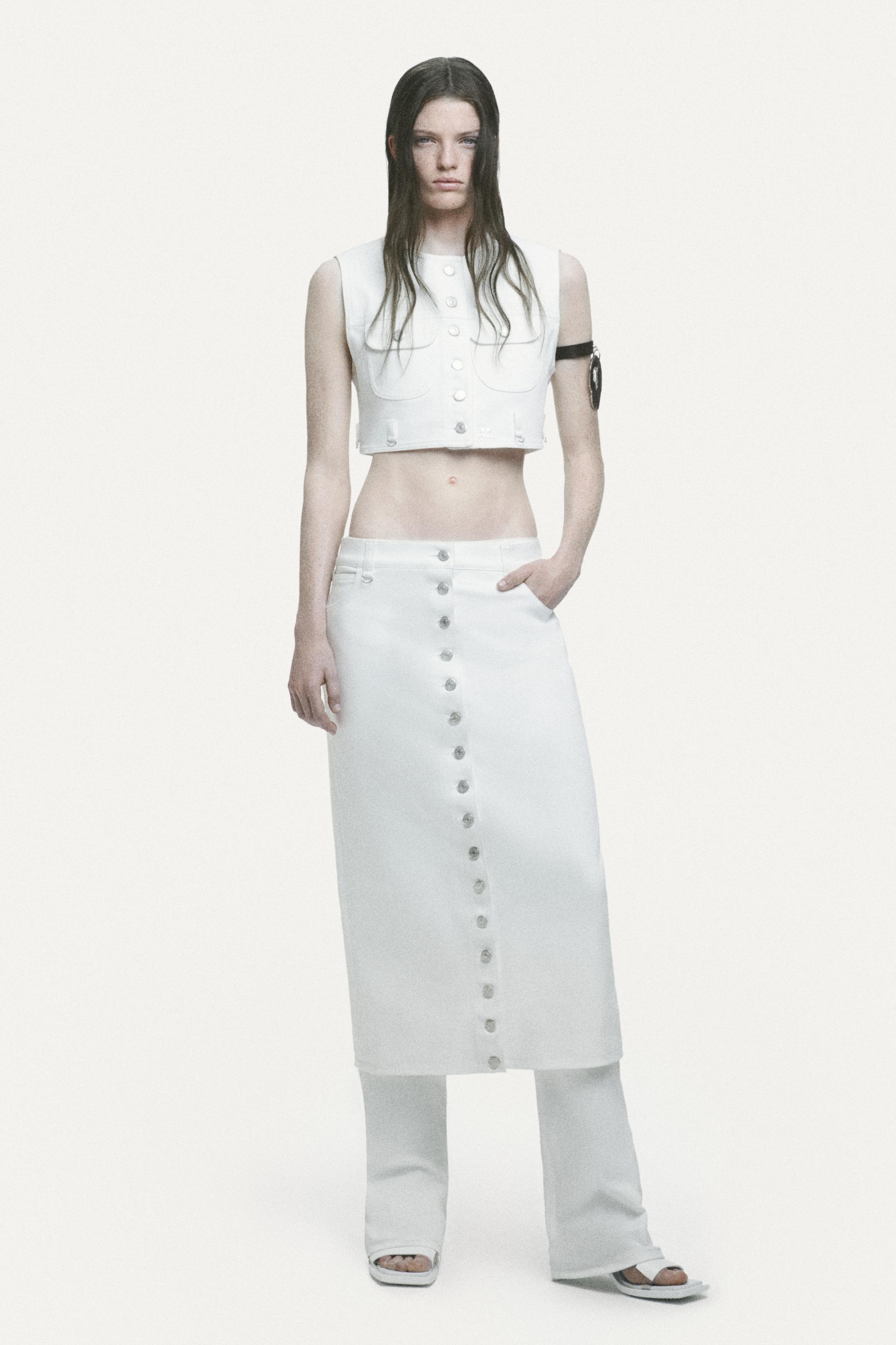 Elegant white crop top and skirt outfit featuring modern details, Courrèges fashion brand.