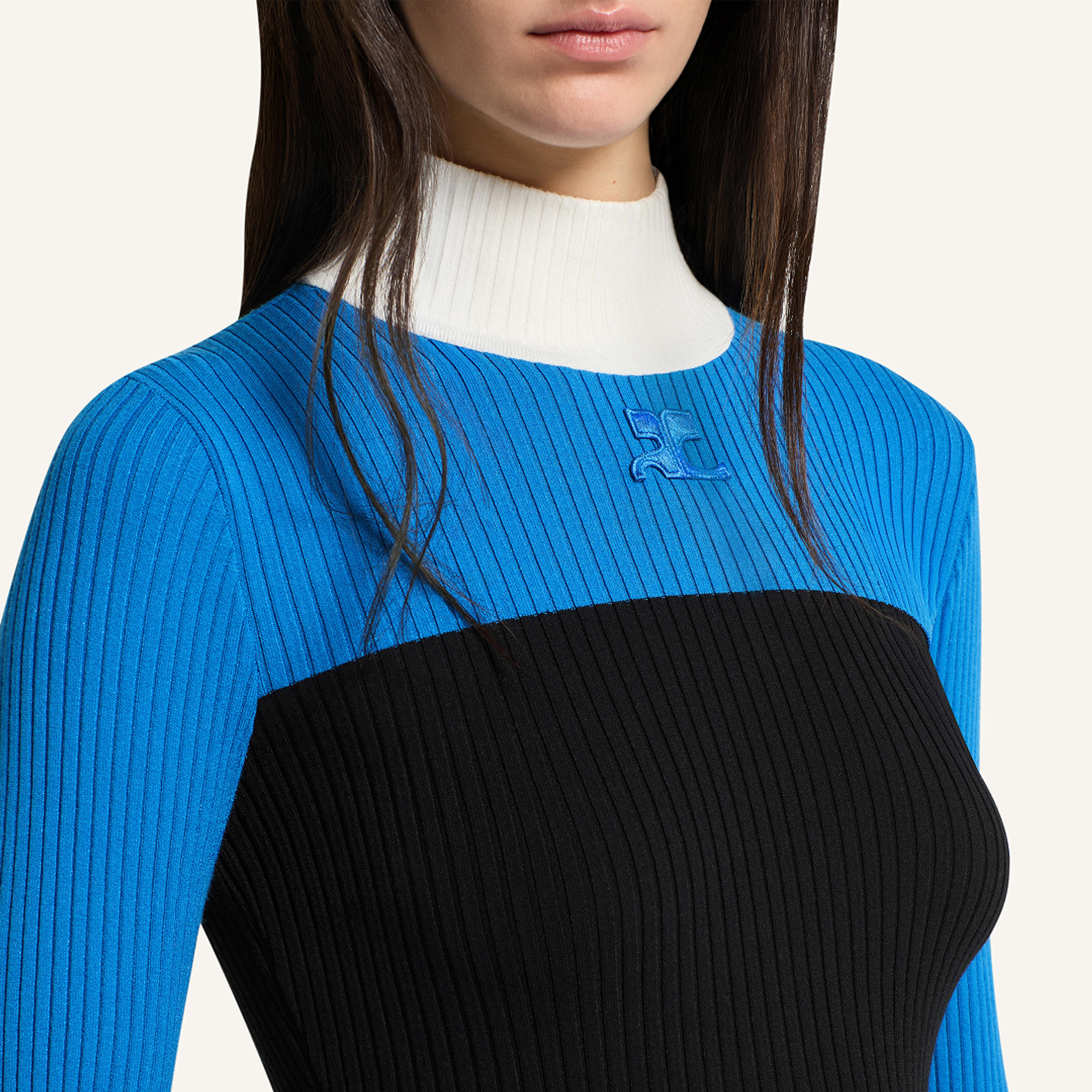 Vue rapprochée élégante d’un haut à rayures bleues et noires de Courrèges, symbole de mode contemporaine.