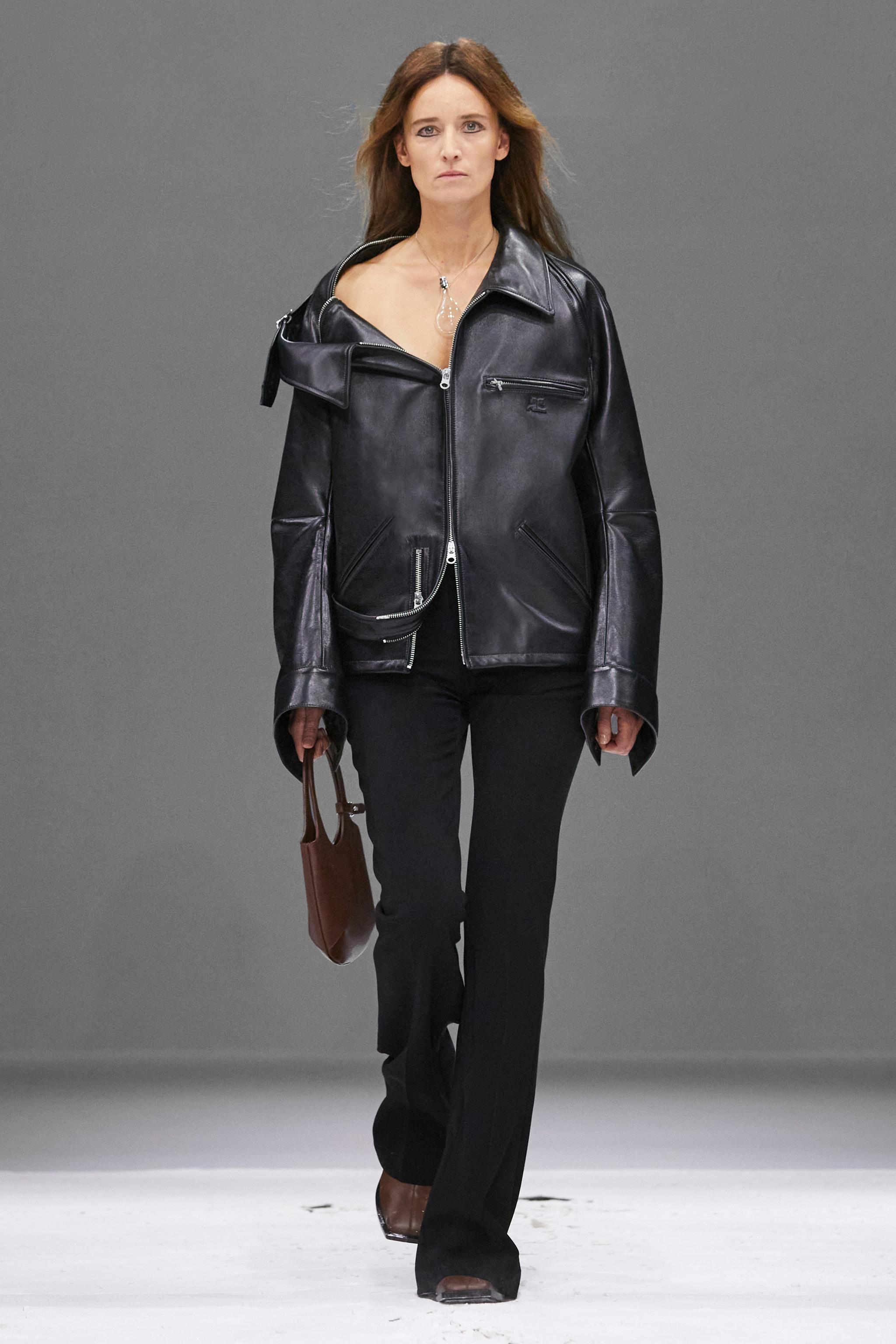 Elegant black leather jacket and trousers from Courrèges, showcased on a runway model.