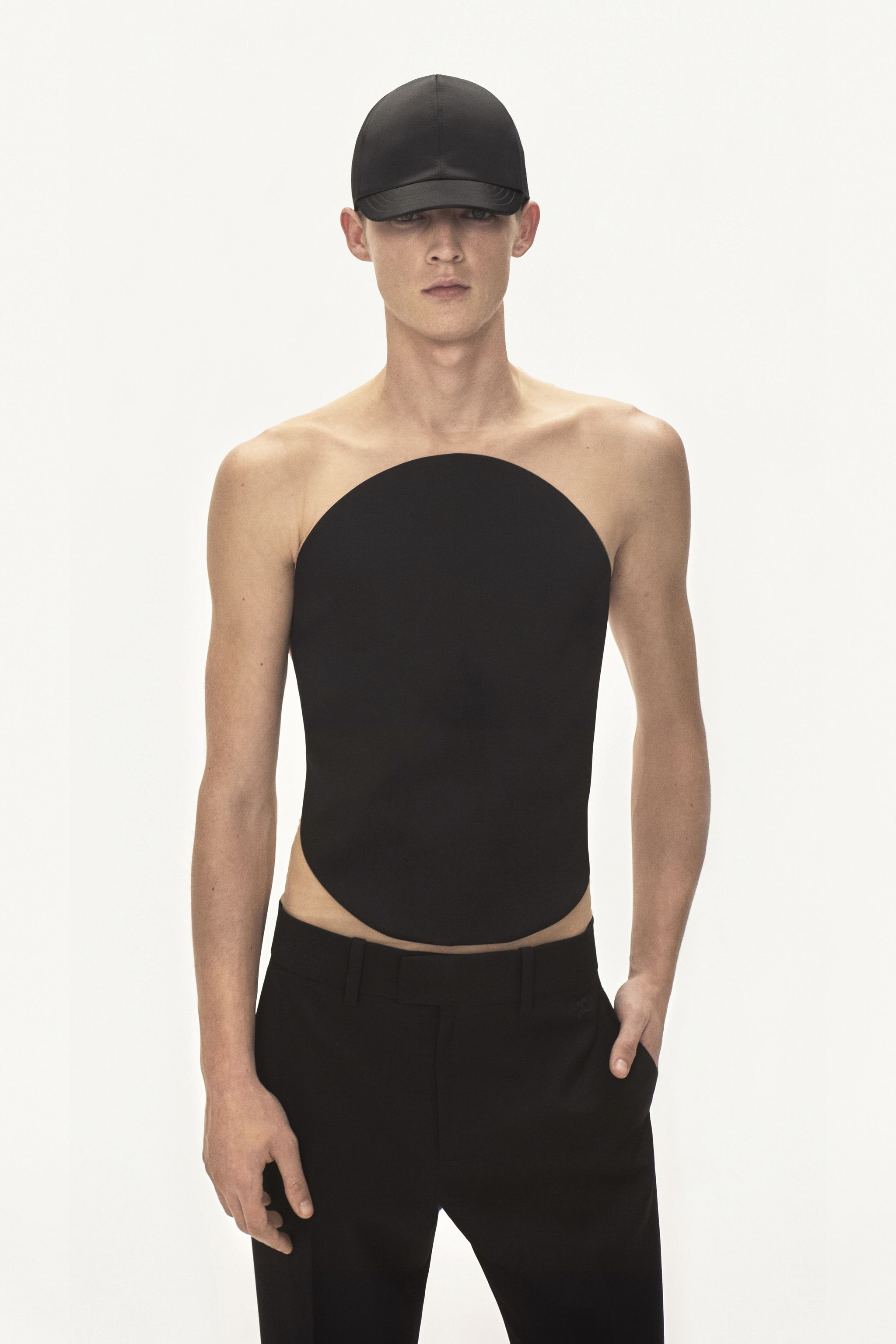 Elegant black sleeveless top with a sleek design, showcased by a male model for Courrèges.