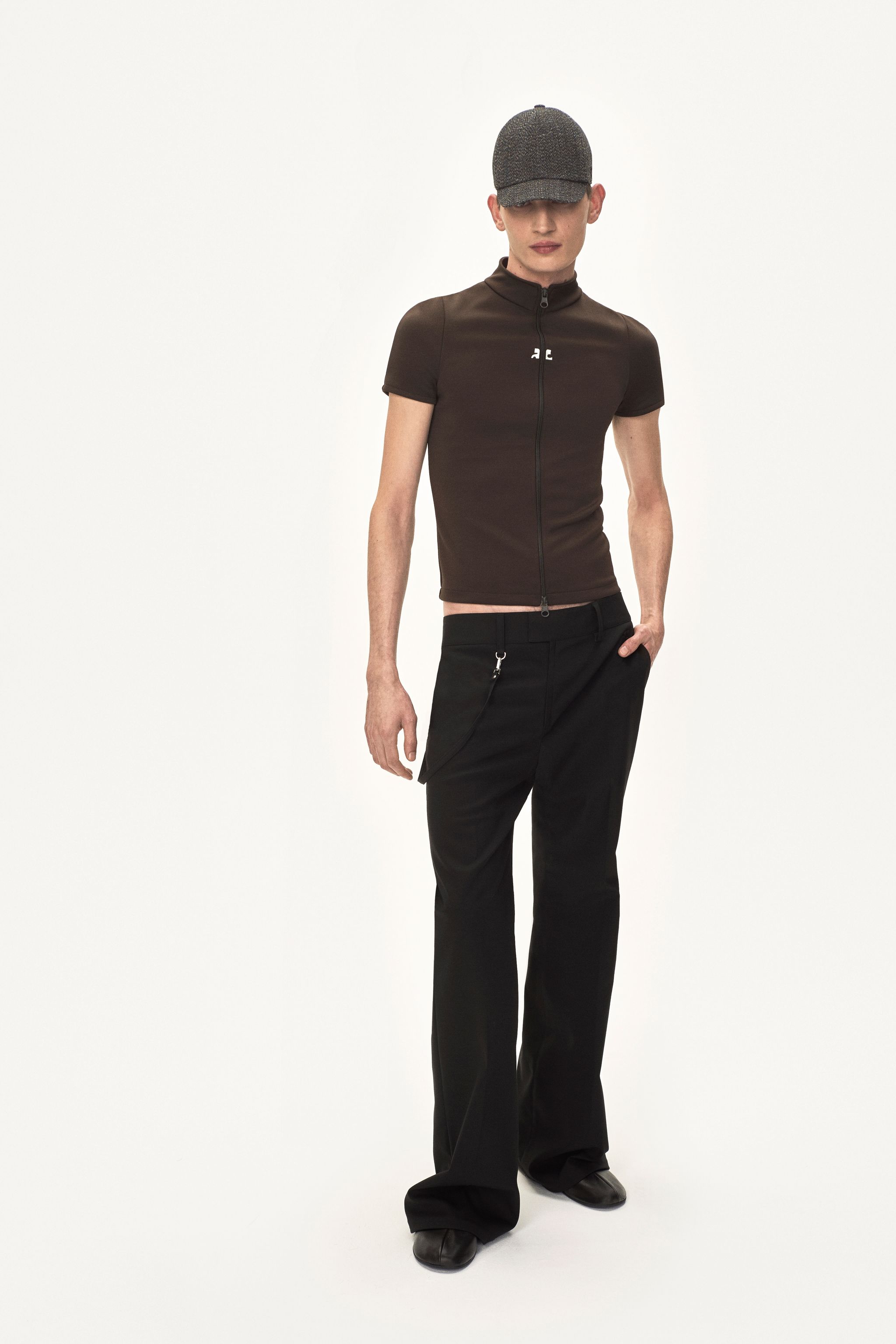 Elegant model in black pants and zip-up top, showcasing Courrèges fashion on an ecommerce site.
