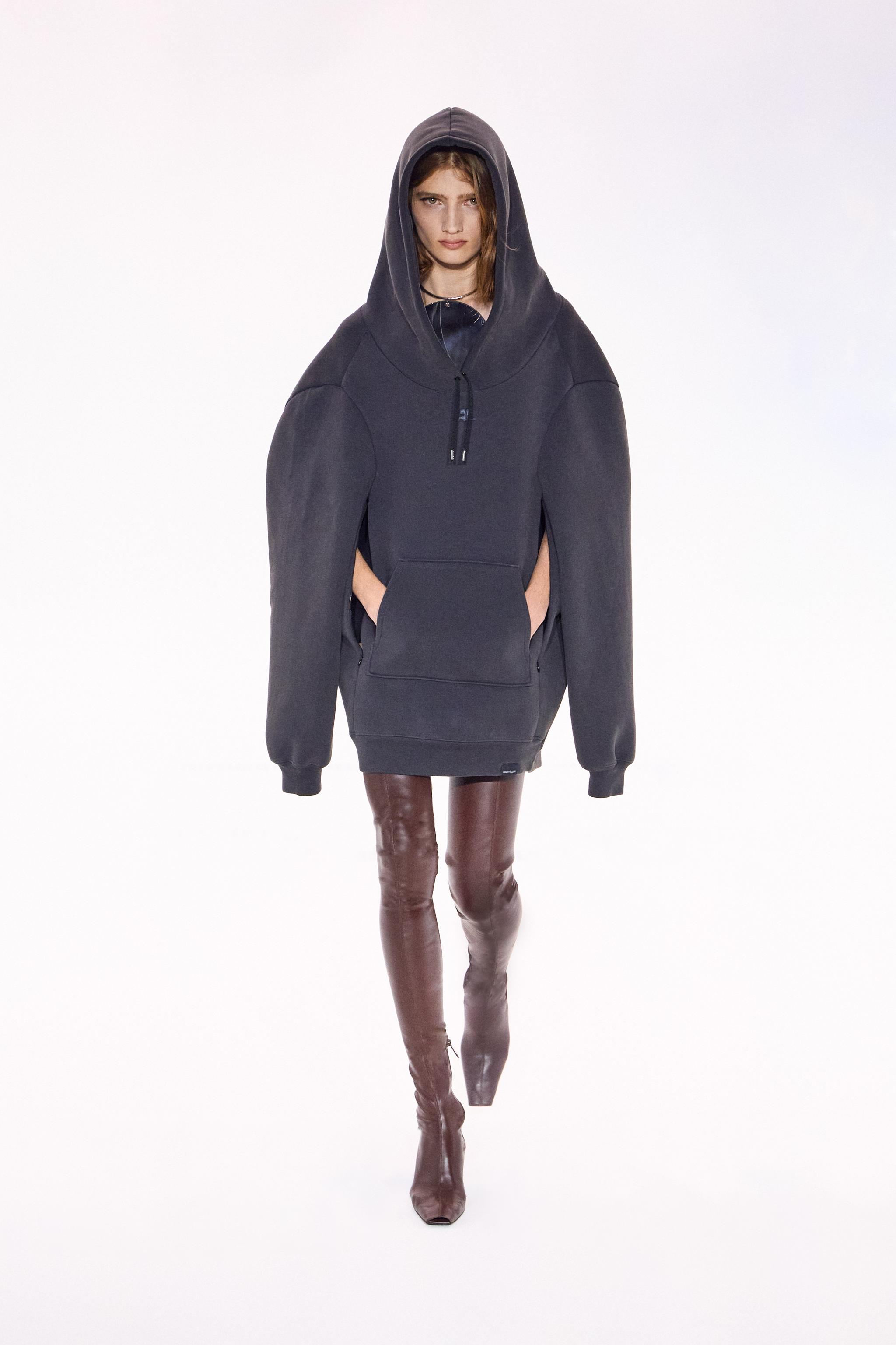 Elegant black oversized hoodie with a front pocket, featured on a fashion runway for Courrèges.