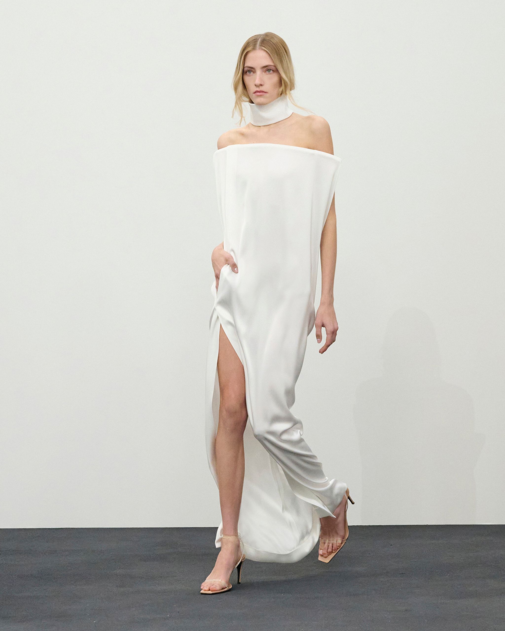 Robe blanche élégante Courrèges avec une fente haute, idéale pour des occasions tendance.