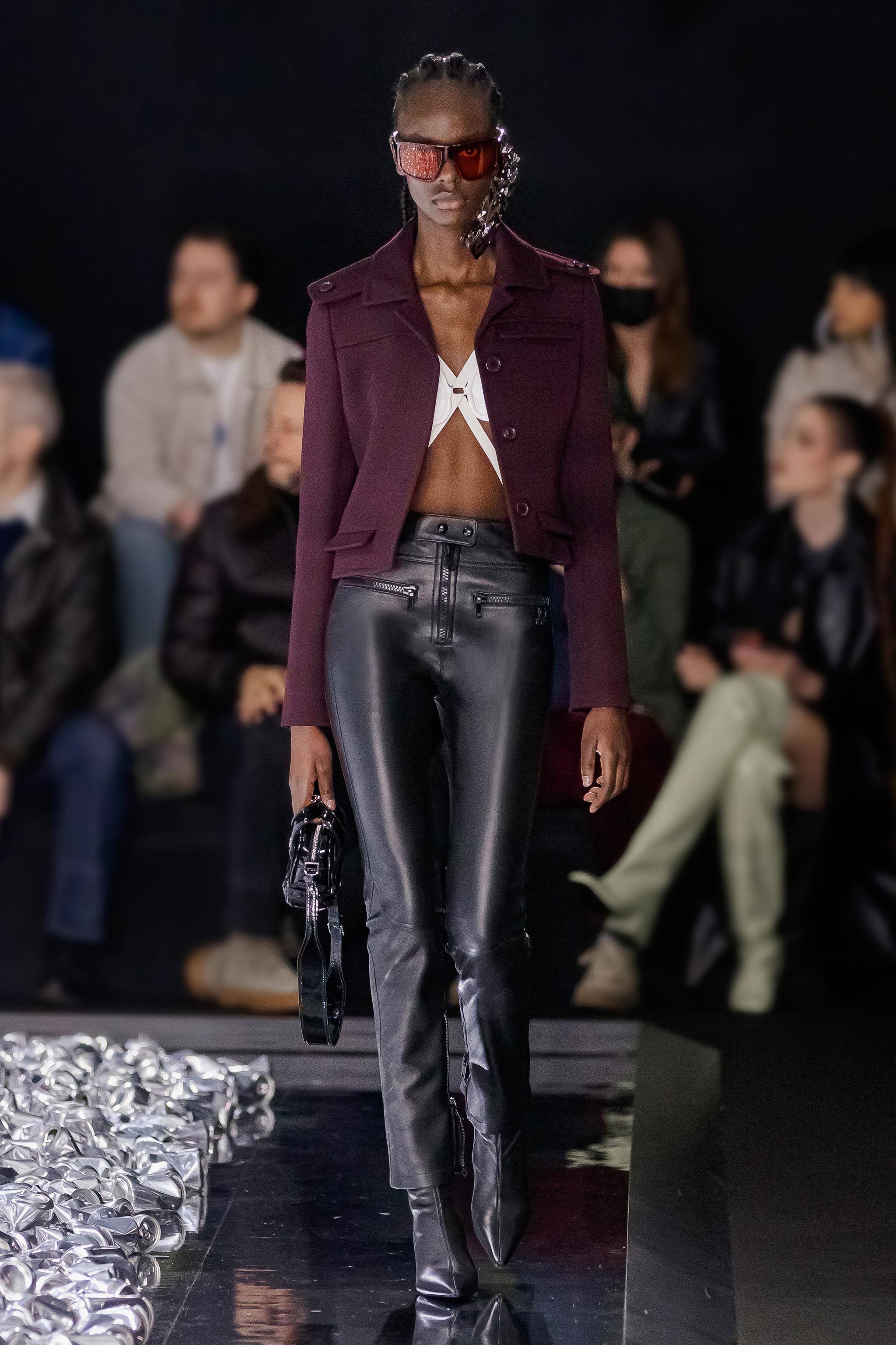 Elegant fashion runway model wearing Courrèges collection, stylish leather pants and modern accessories.