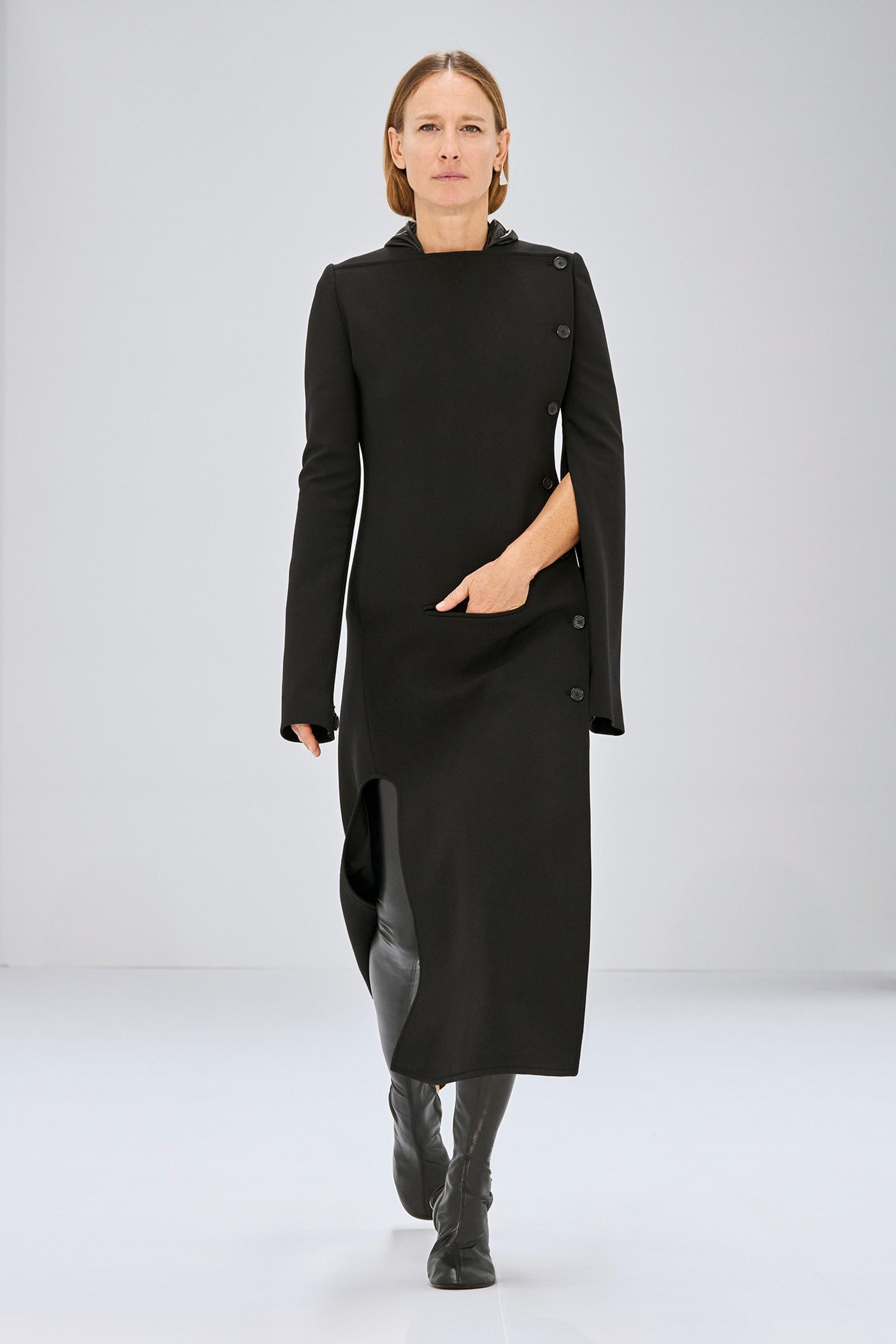 Robe noire élégante de Courrèges avec boutons asymétriques pour un look moderne et chic.