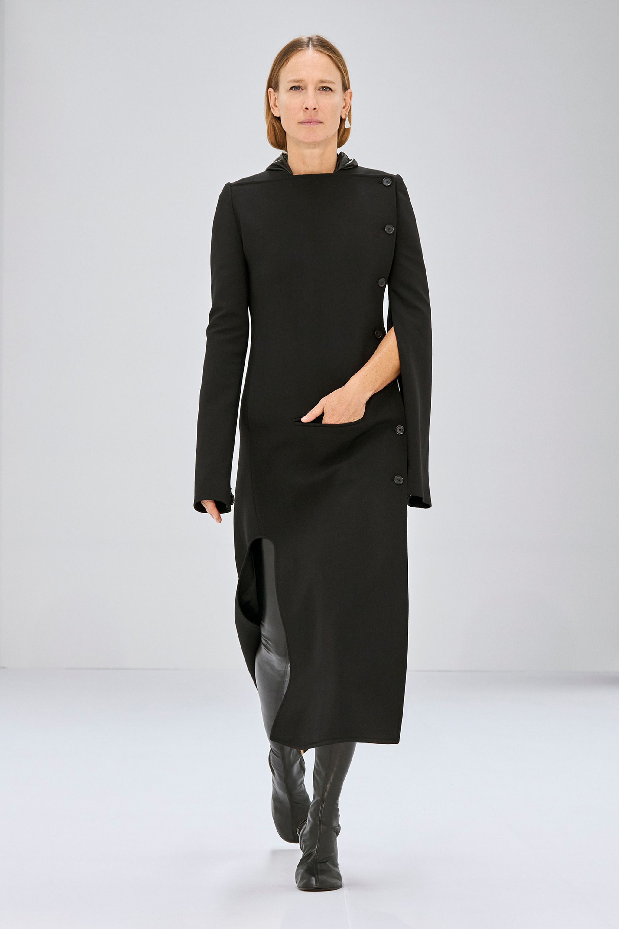 Elegant black Courrèges dress with side button details and a modern asymmetric hemline.