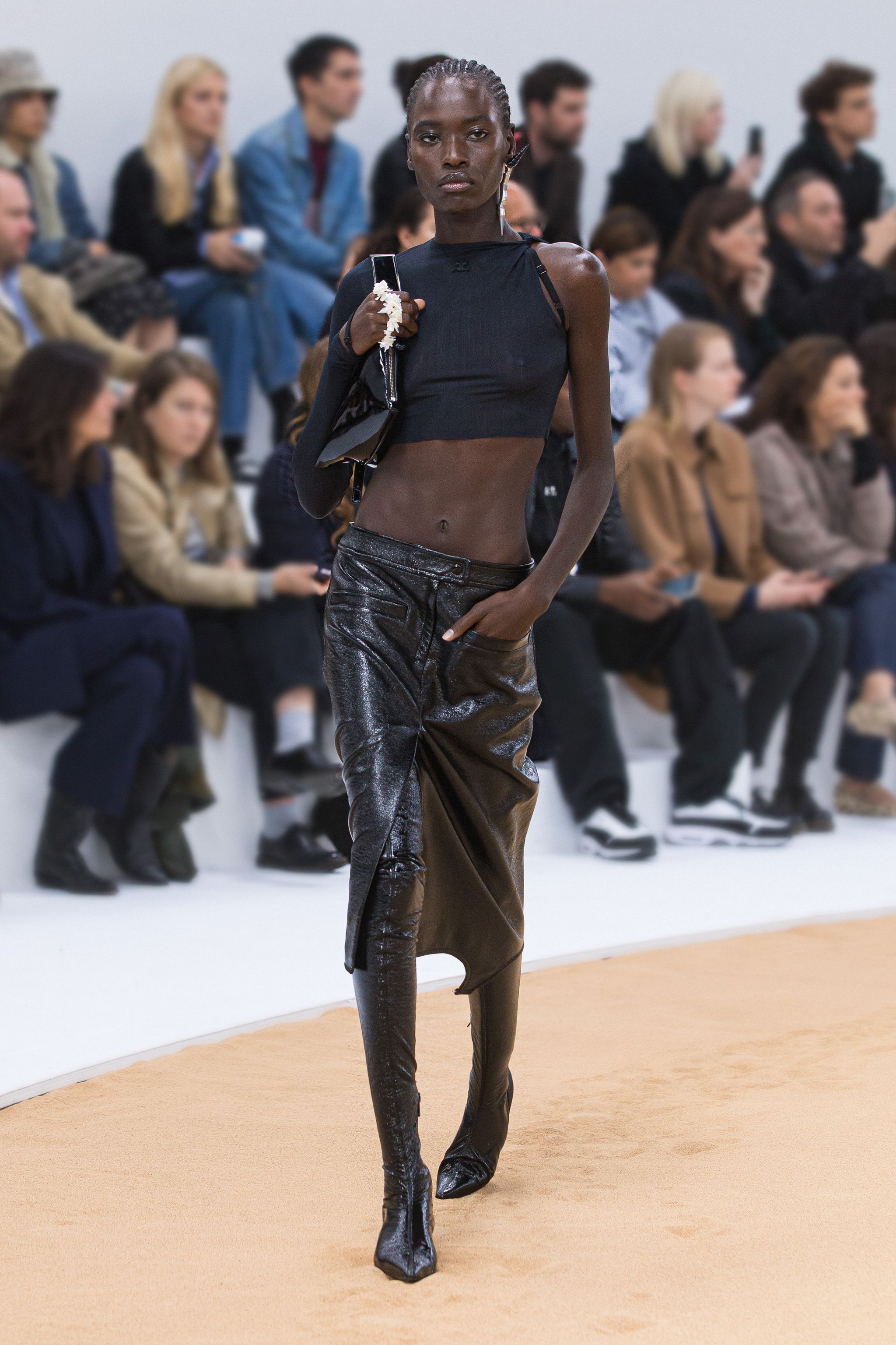 Elegant black crop top and metallic pants showcased at Courrèges fashion show, ideal for trendy style.